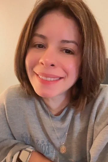 A young woman with shoulder-length brown hair smiling at the camera.