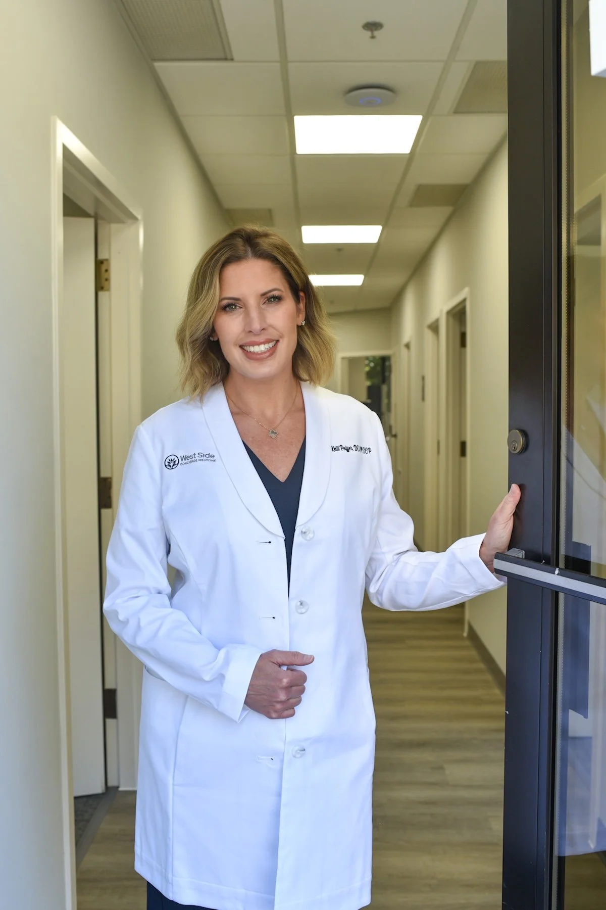 Dr. Kelli Peiffer holding a door open in Akron.