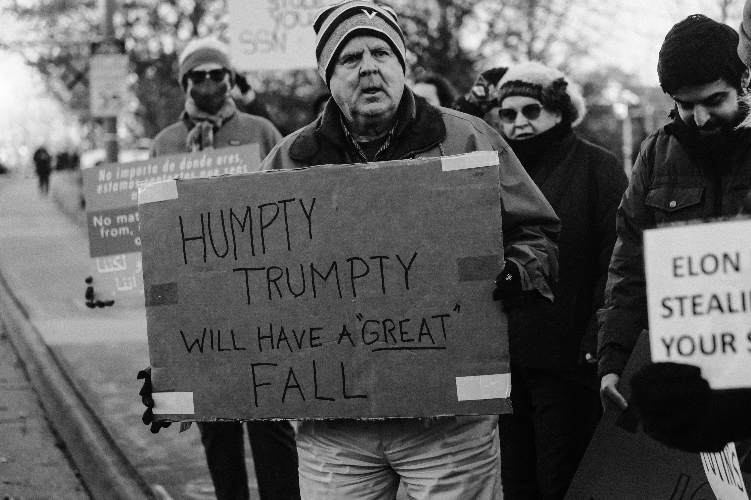 An older man holds an anti-Trump sign in February.