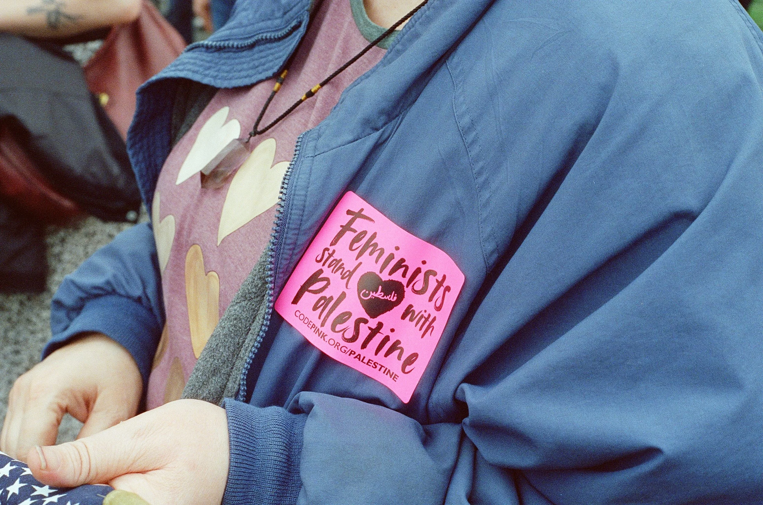 A woman with a "Feminists stand with Palestine" sticker.