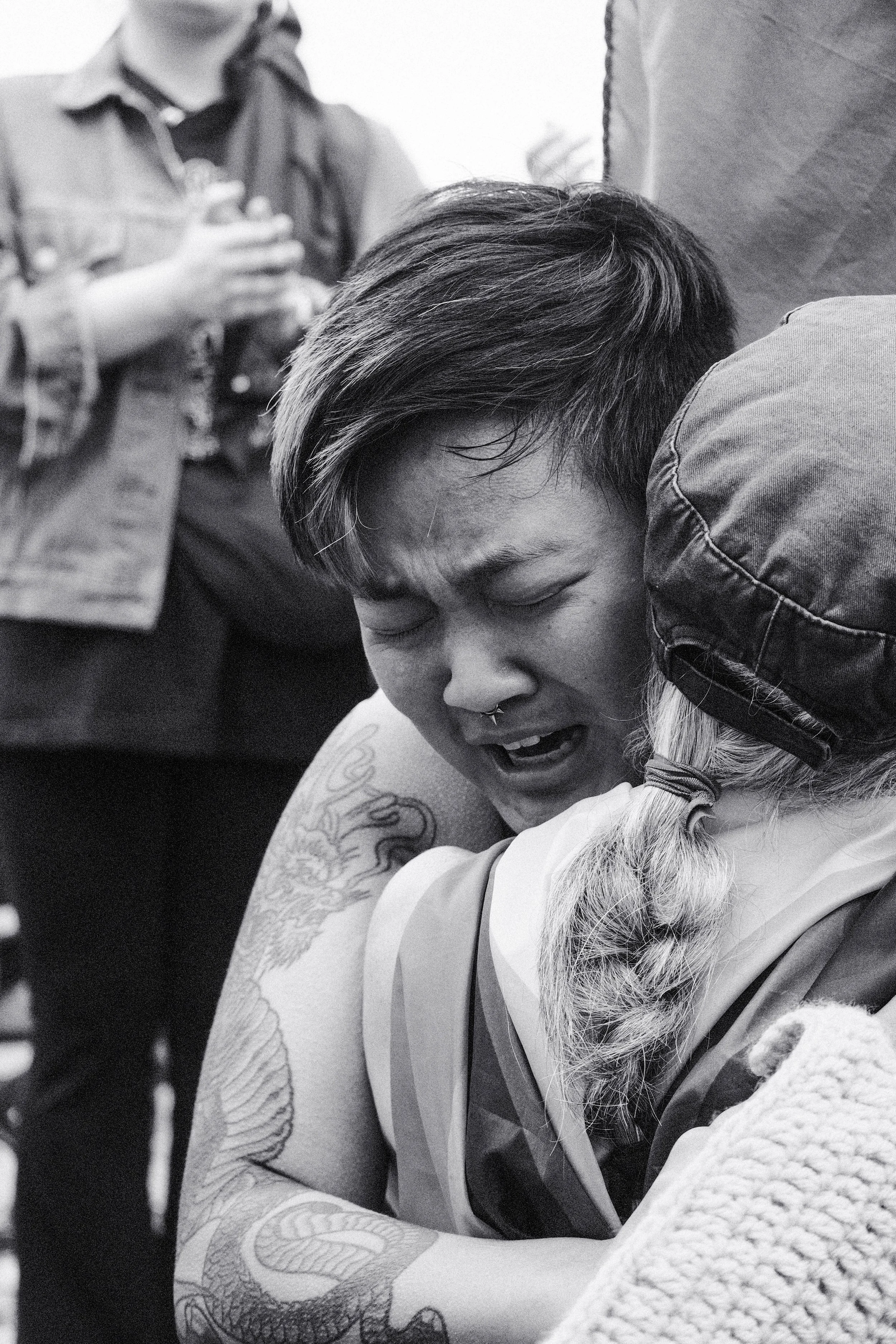 An individual cries hugging a fellow protester.