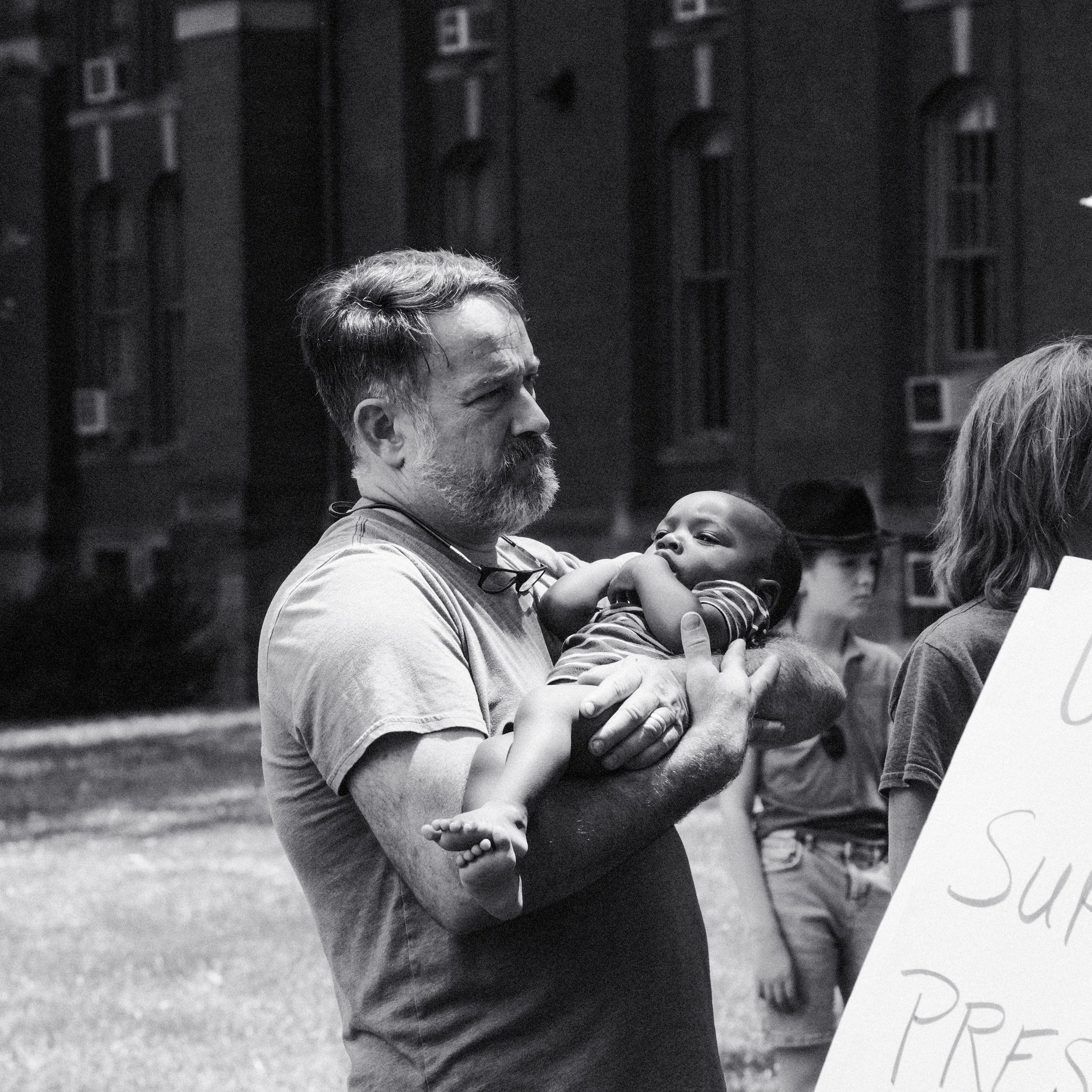 A man brings his baby to a rally for Jim Ryan.