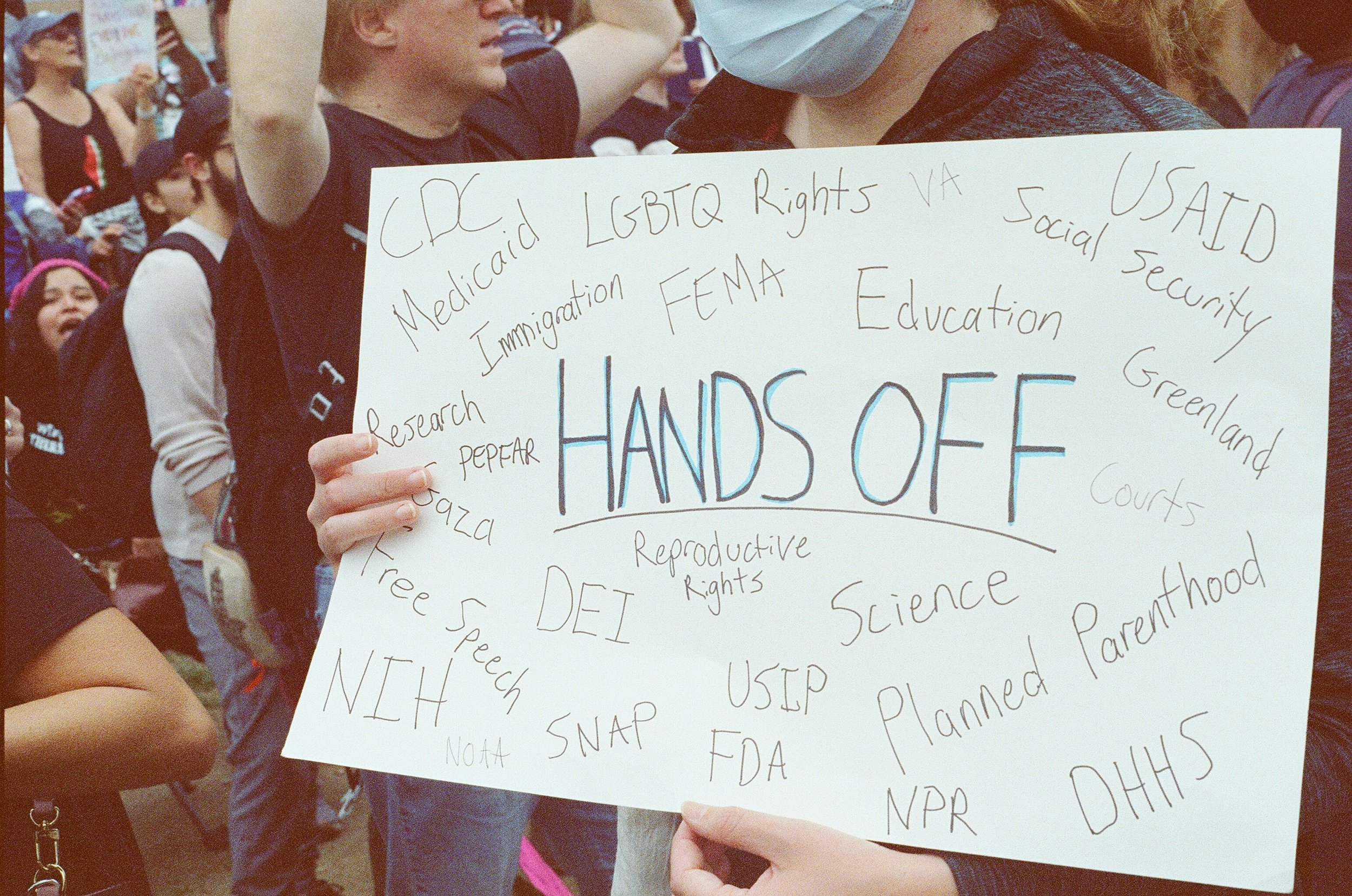 Protester demanding an end to federal cuts and tyranny.