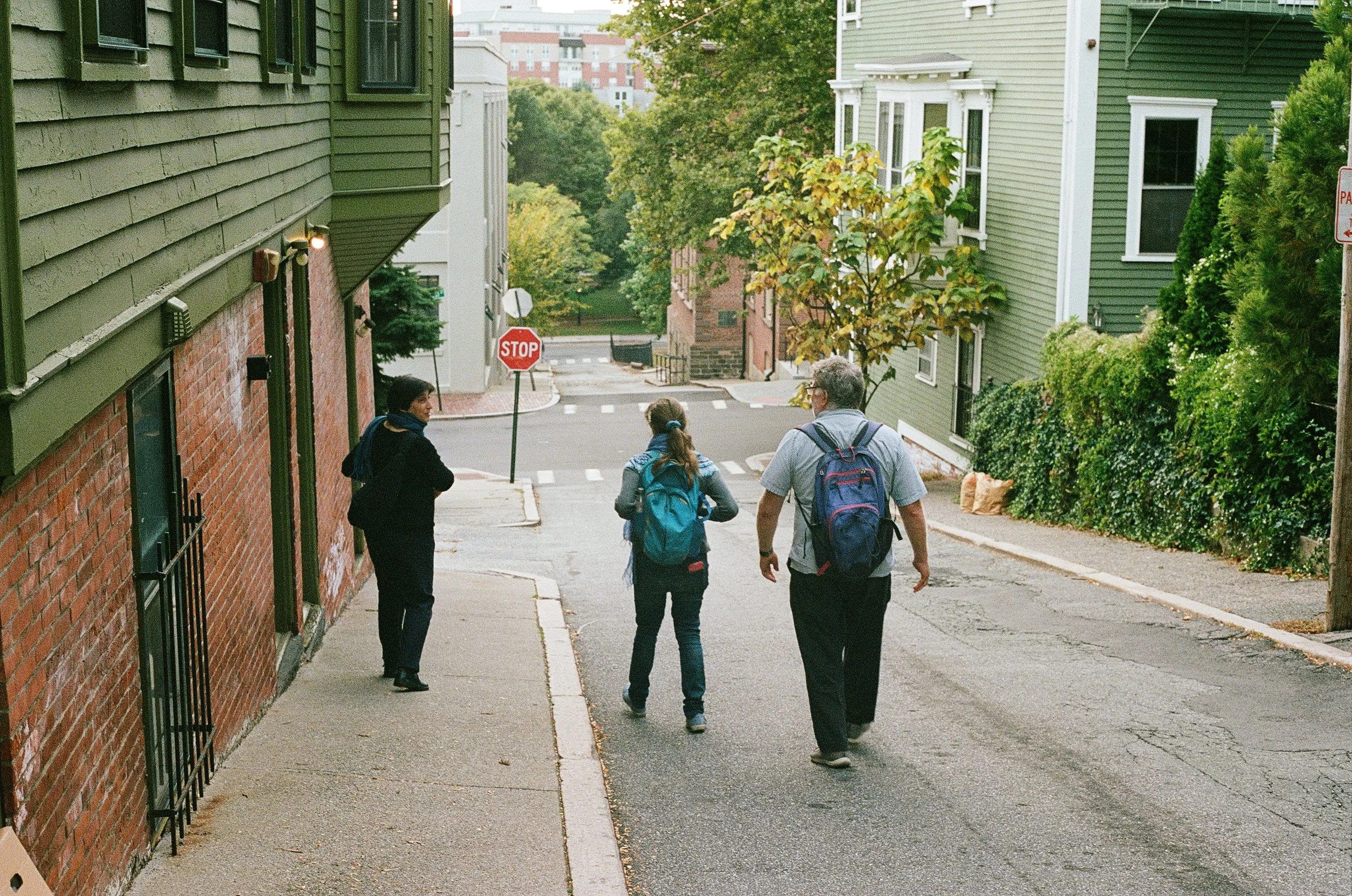 Three people walking down a street in Providence, Rhode Island.