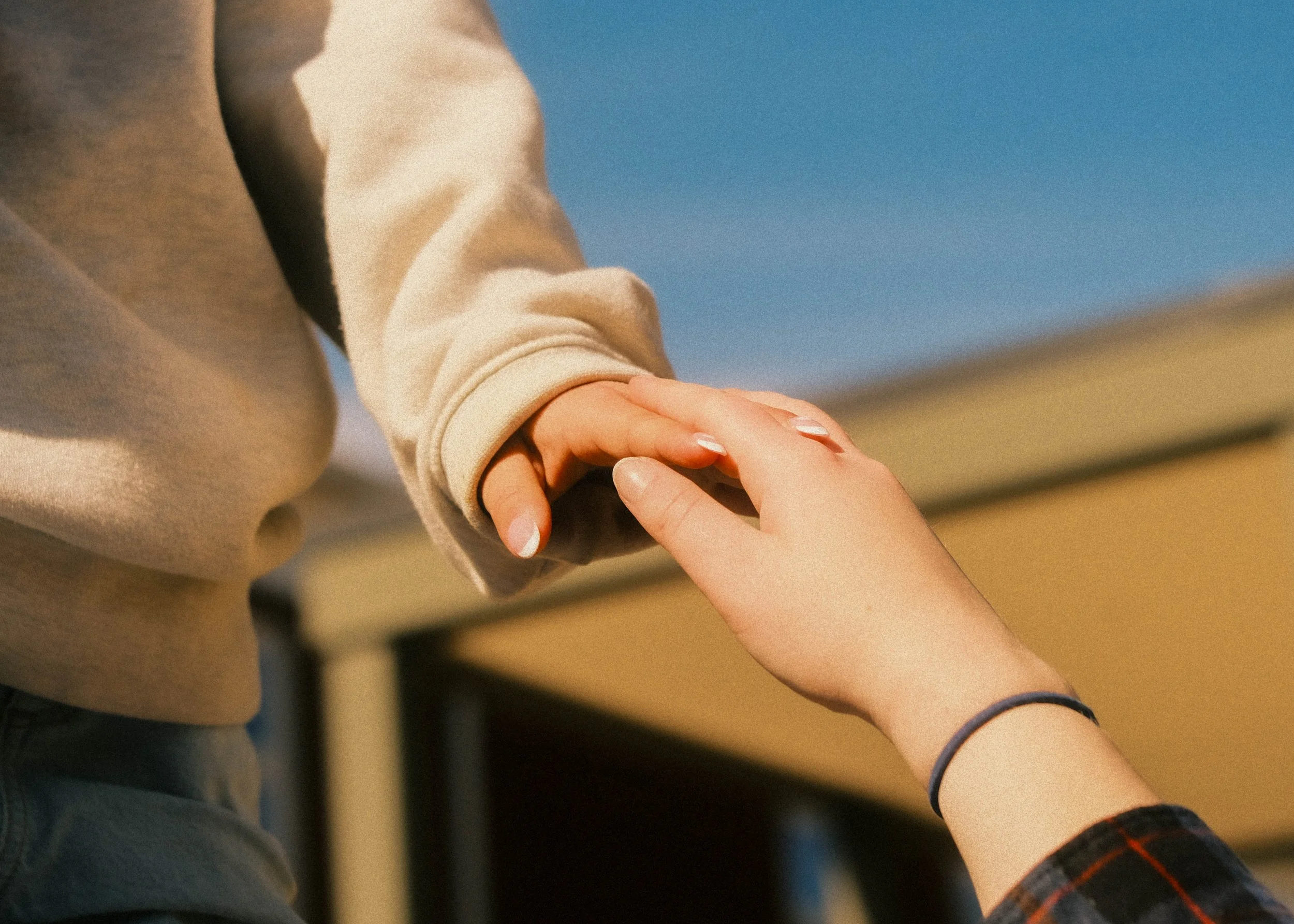 Two friends hold hands.