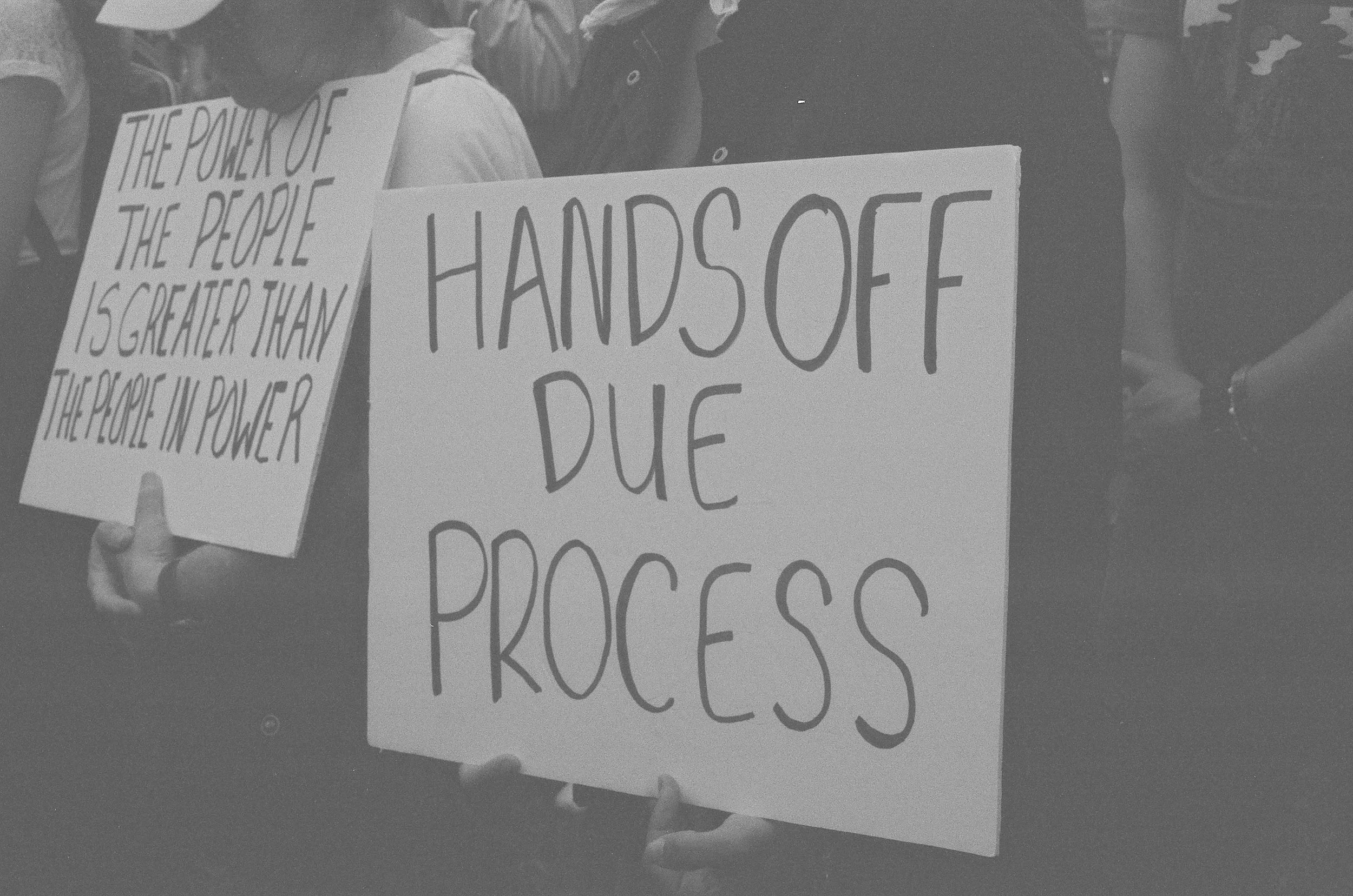 Protesters with signs demanding an end to federal overreach in the judiciary.