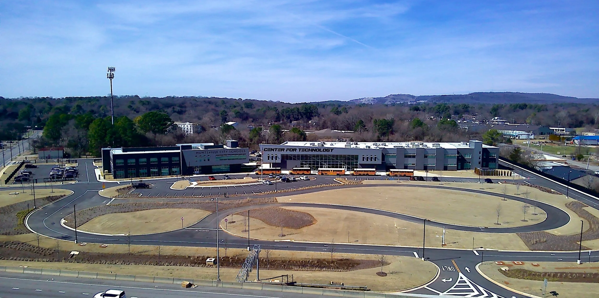 Aerial view of Huntsville City Schools Center for Technology with parking lot, roadways, and surrounding hills.