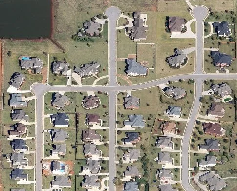 Aerial view of a suburban neighborhood with houses, streets, and yards.