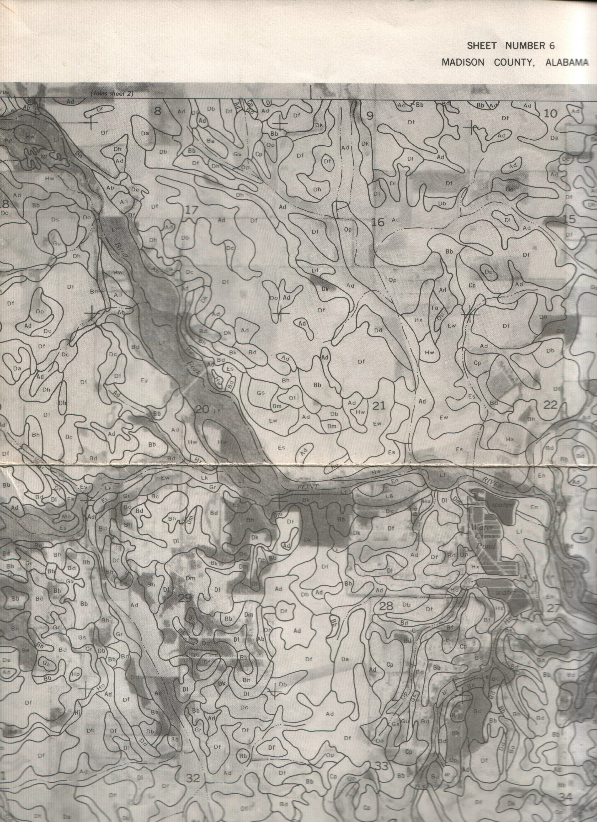 A black and white topographical map of Madison County, Alabama. The map features contour lines, rivers, and various sections labeled with numbers and codes.