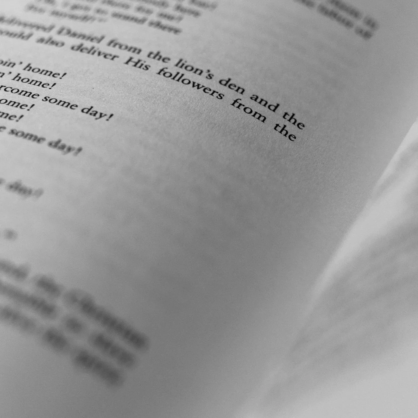 Close-up of an open book page, showing a paragraph and some lines of text.