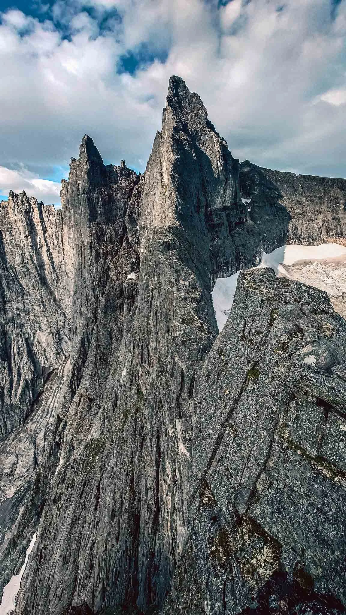 Fjellrør med store steiner og snø, under en skyet himmel.