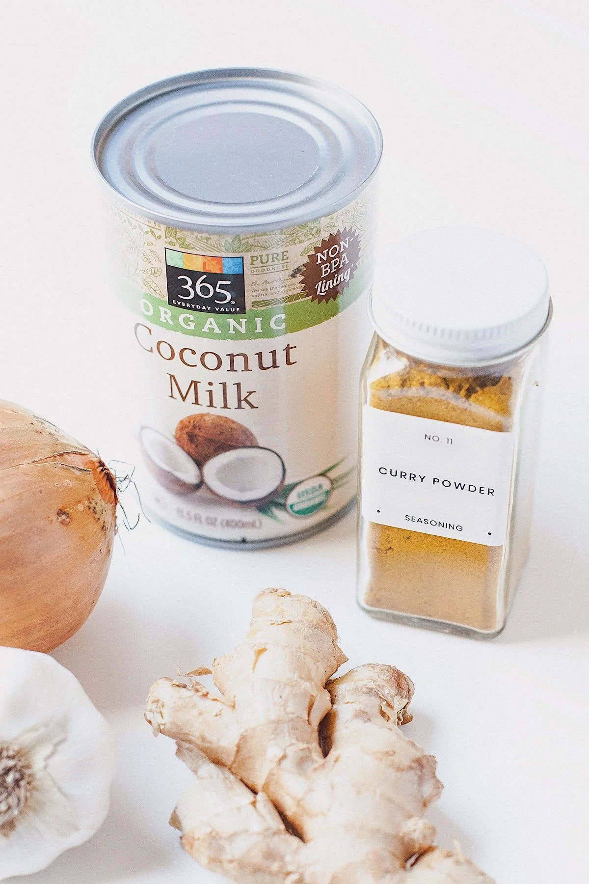 Ingredients for easy coconut curry including coconut milk, curry powder, onion, garlic, and fresh ginger.