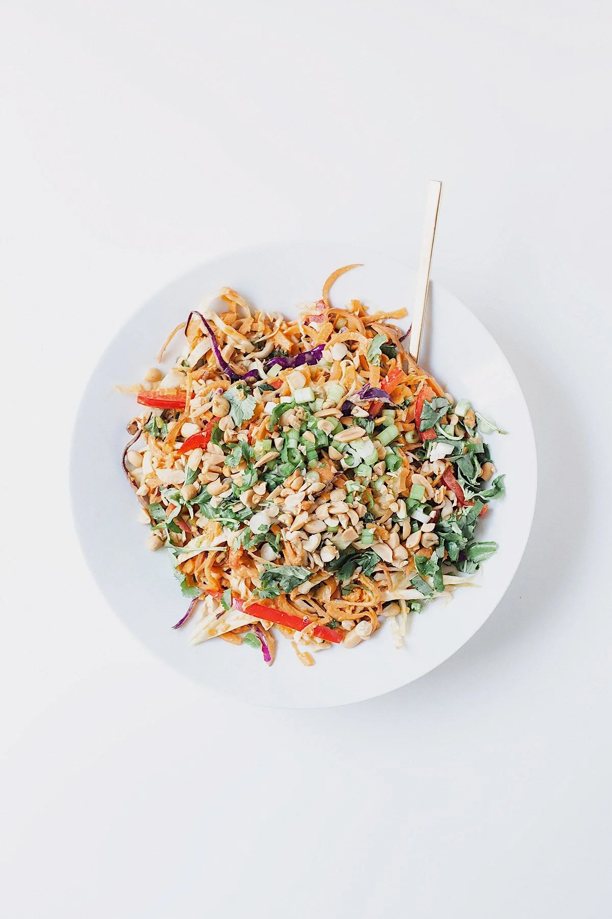 Sweet potato noodles topped with coconut peanut sauce and fresh herbs.