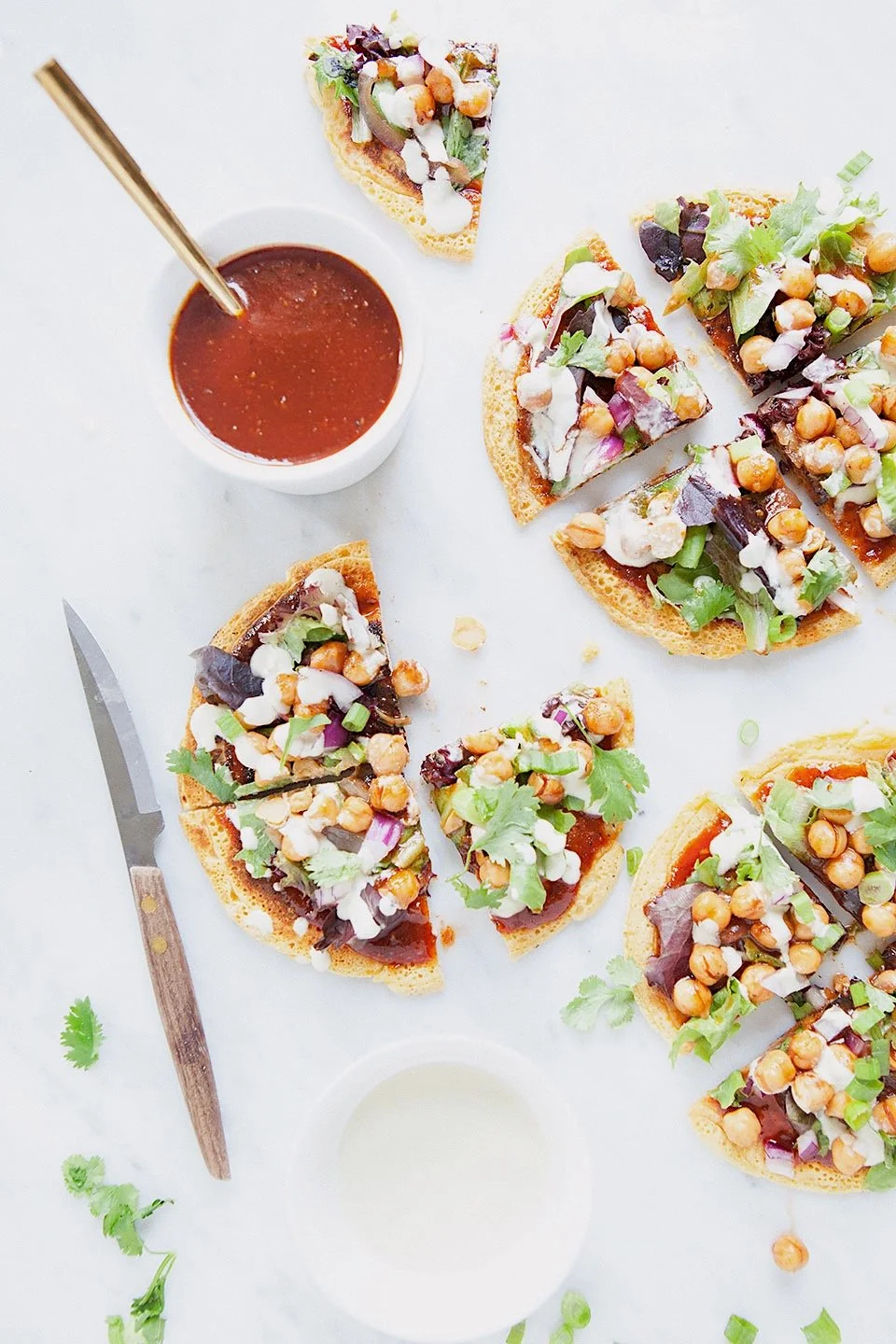 Mini socca pizzas topped with barbecue chickpeas, greens, and vegan ranch.