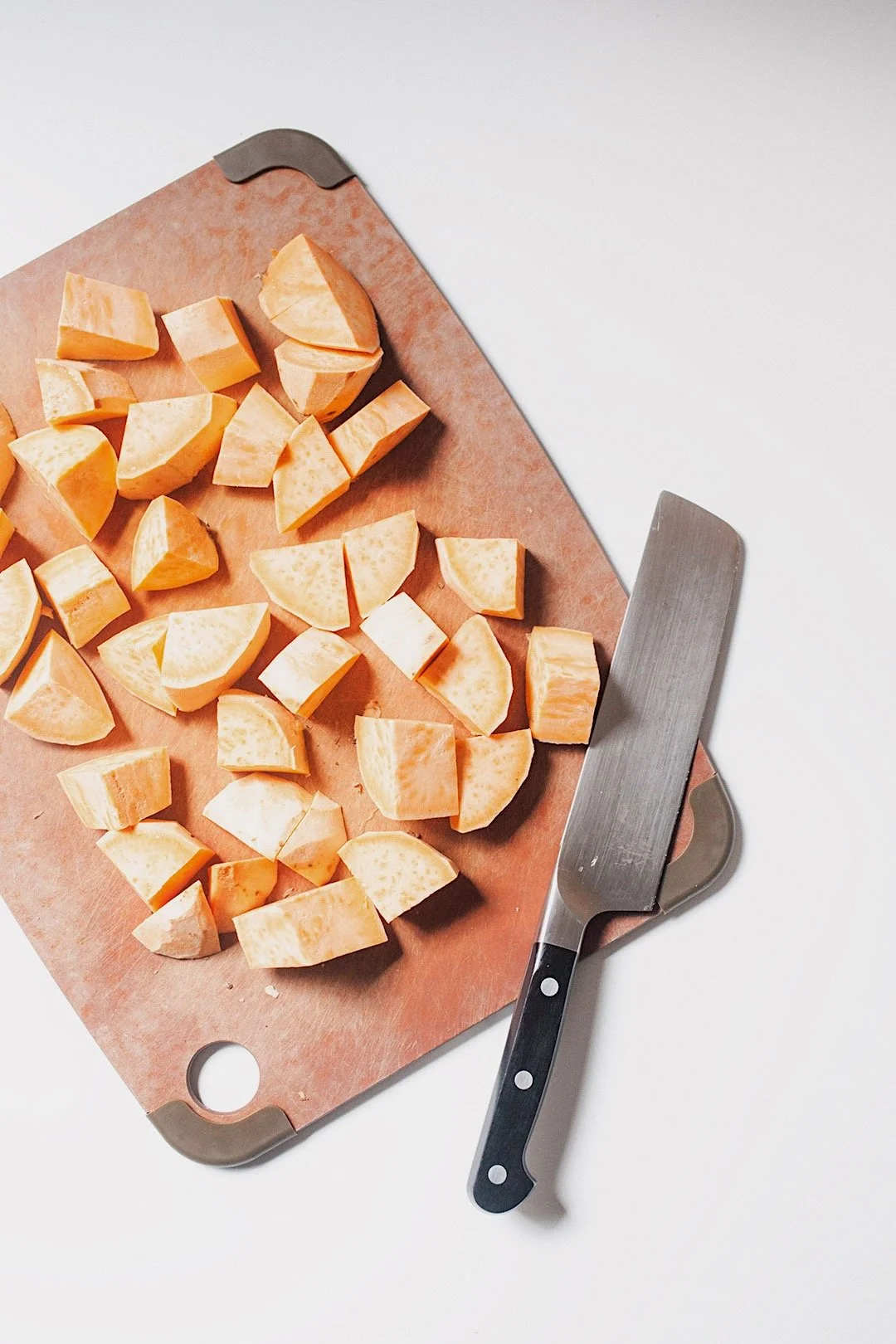 Cubed sweet potatoes on cutting board ready for boiling for Moroccan shepherd’s pie.