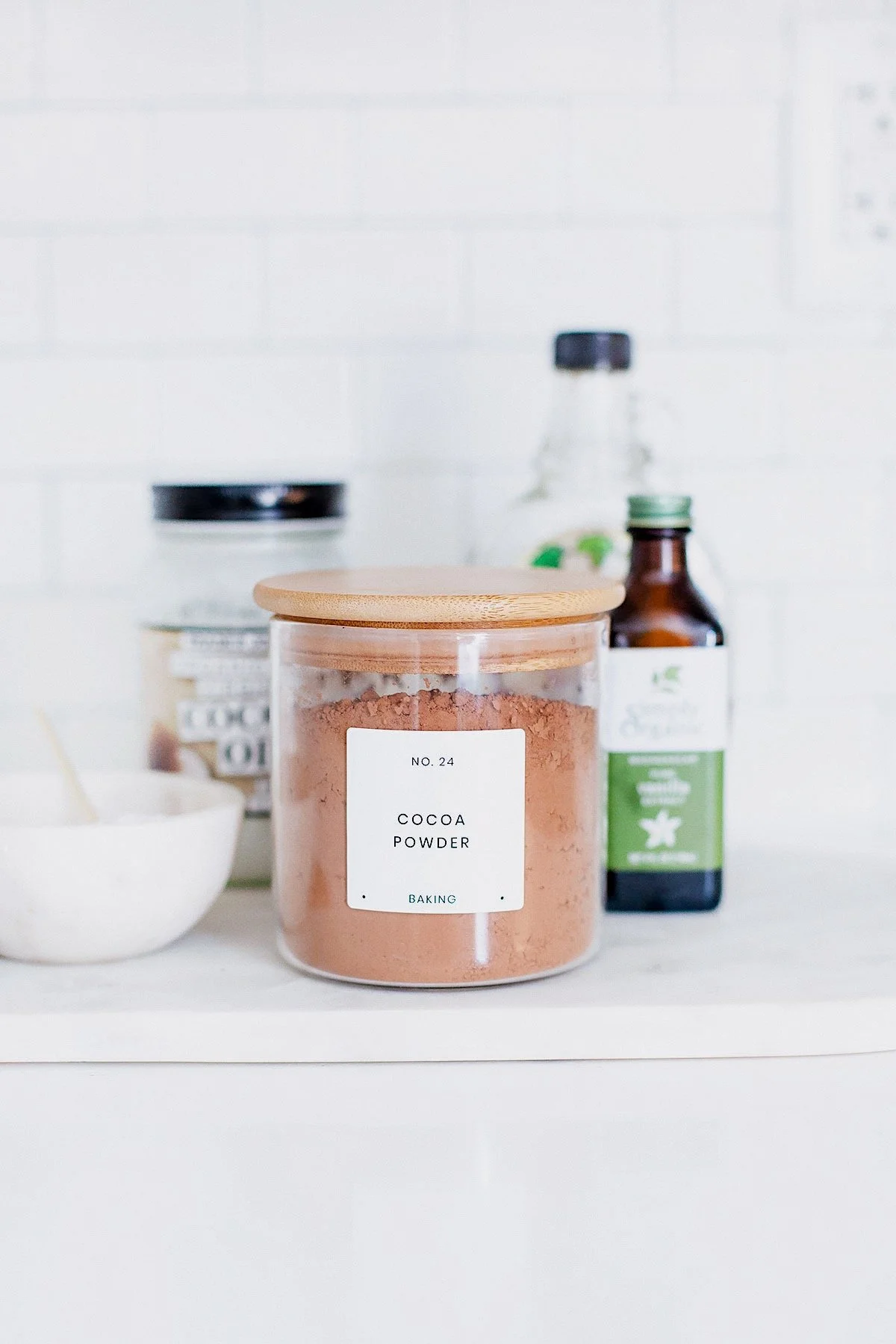 Cacao powder, coconut oil, and maple syrup on a counter.