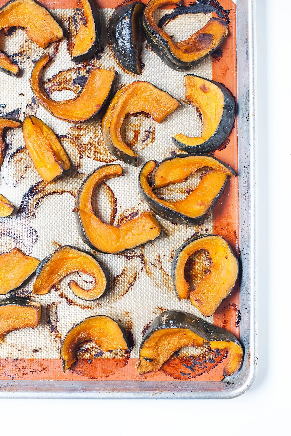 Kabocha squash wedges arranged on a baking sheet for roasting