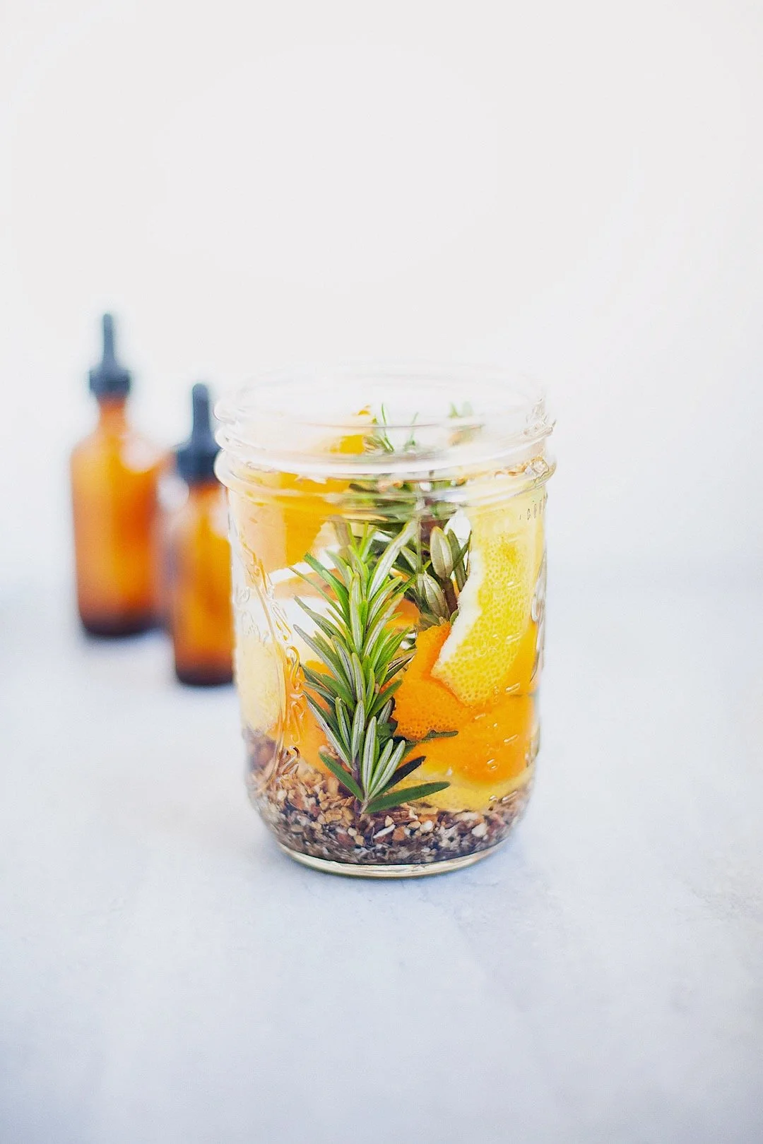 Homemade digestive bitters process with fresh herbs and glass jars.