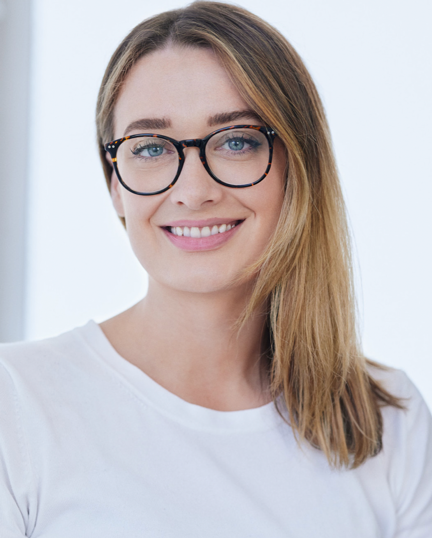 A woman with glasses and long, light brown hair, smiling at the camera.