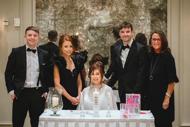 Group of five people at a celebration table with candles and decorations