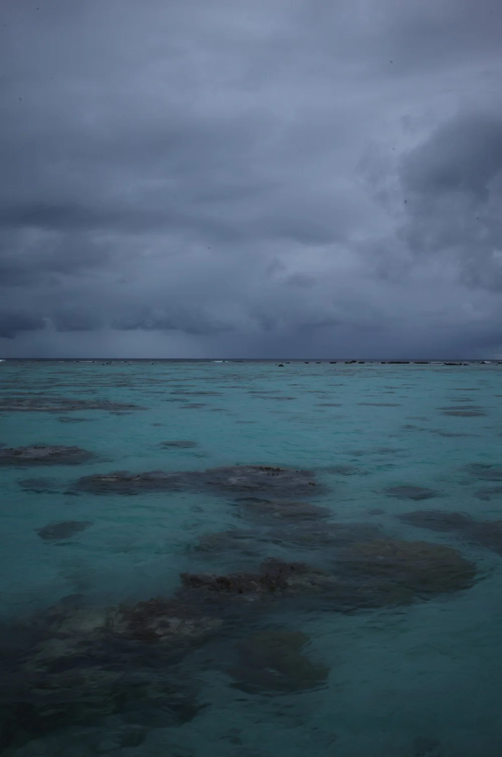 South Pacific Blue by MrSpacetime: storm clouds over a turquoise reef lagoon in French Polynesia