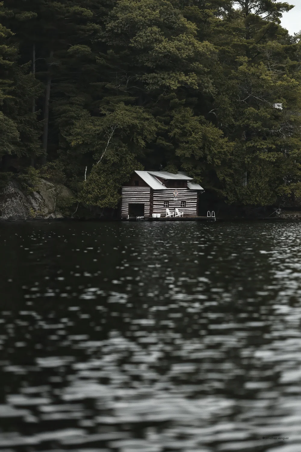 Striped Boathouse by MrSpacetime: a classic striped boathouse on a forested Lake Joseph shore