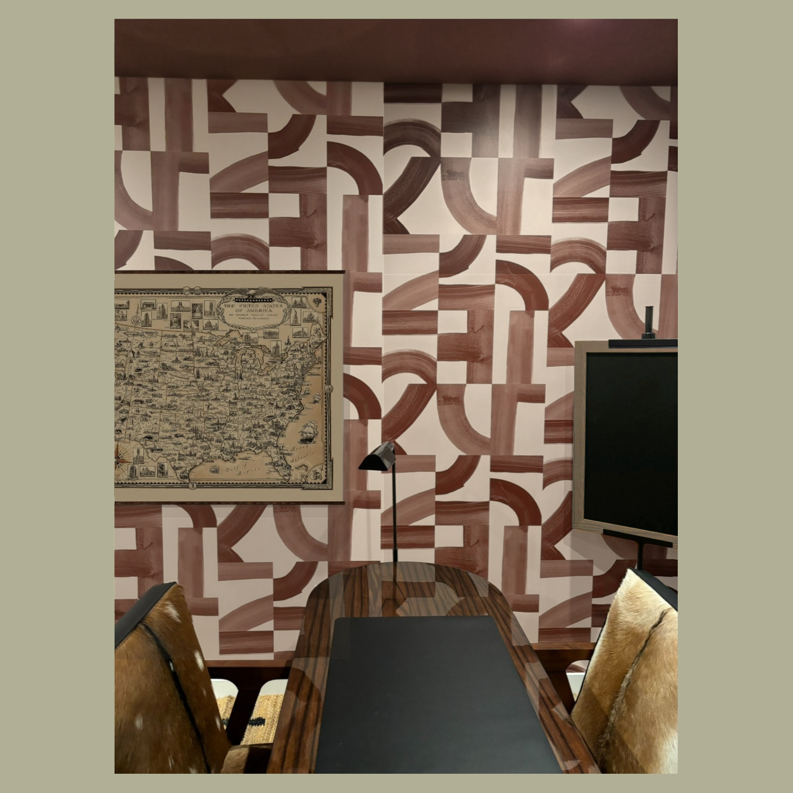 A room designed by Austin interior designer HOLLEYHOUSE with a geometric patterned wallpaper in shades of brown and beige, a framed vintage map of the United States on the wall.