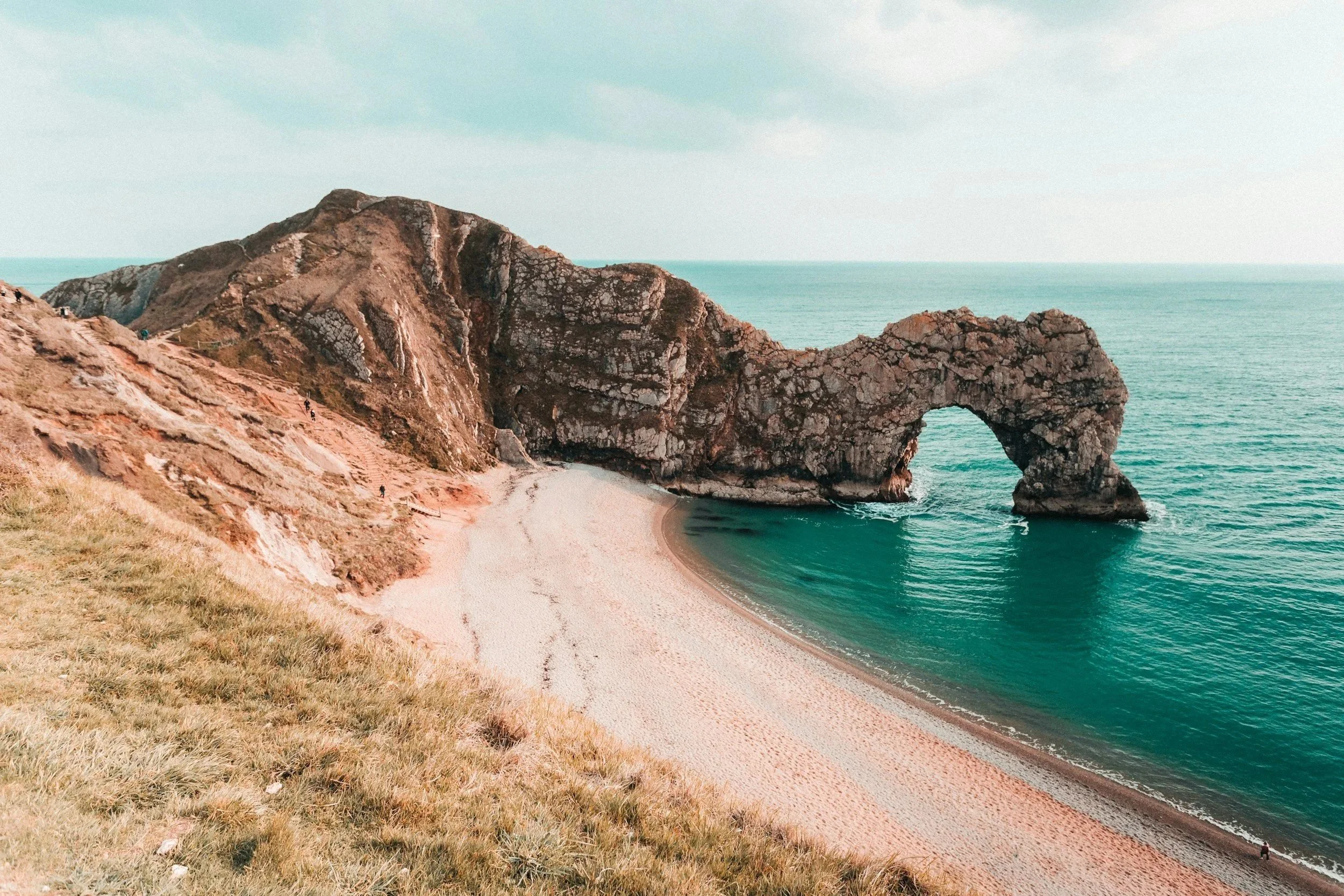 Cliff with natural arch over a sandy beach on the coast