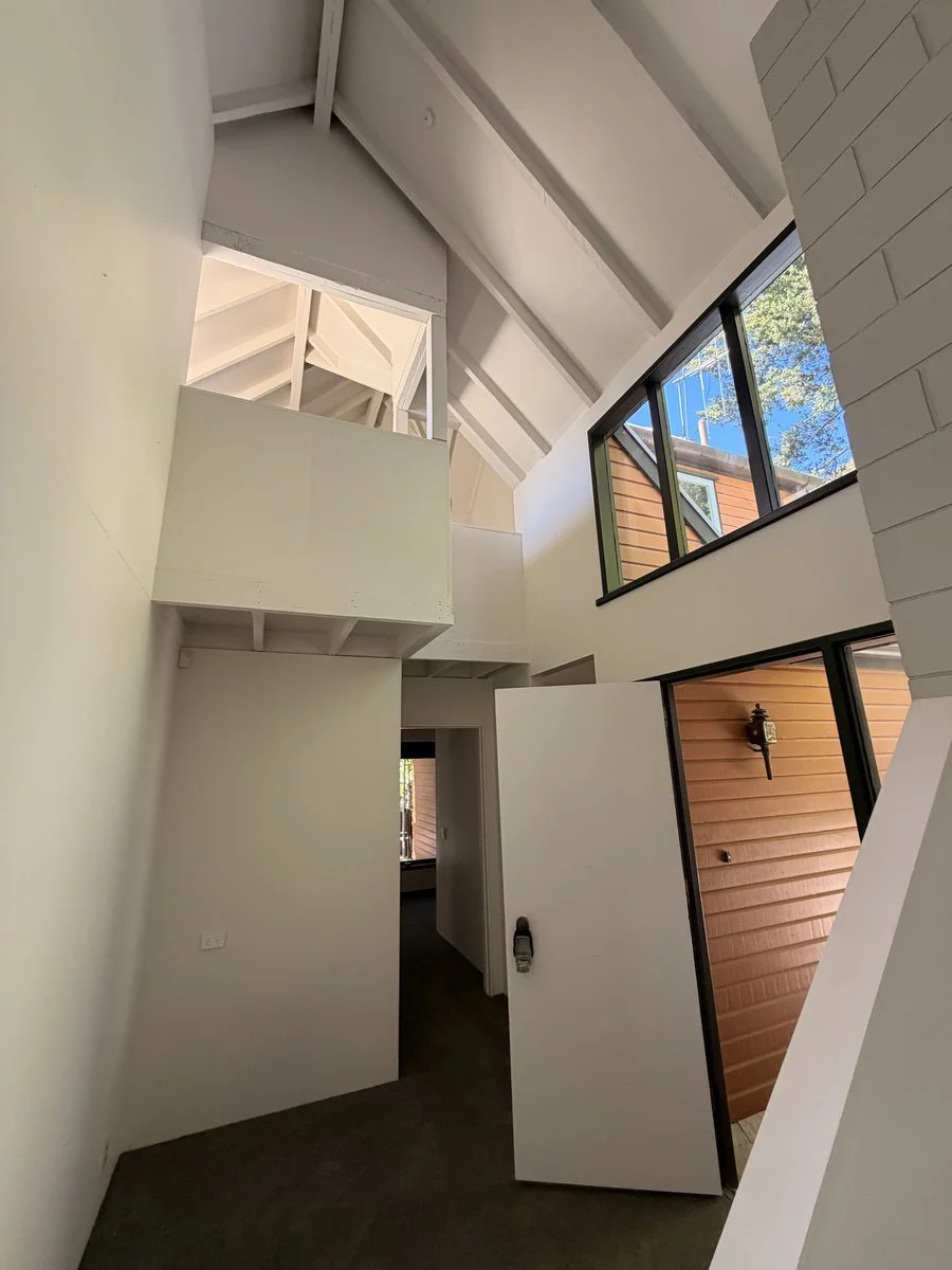 interior-double-height-entry-white-painted-walls-exposed-beams.jpg