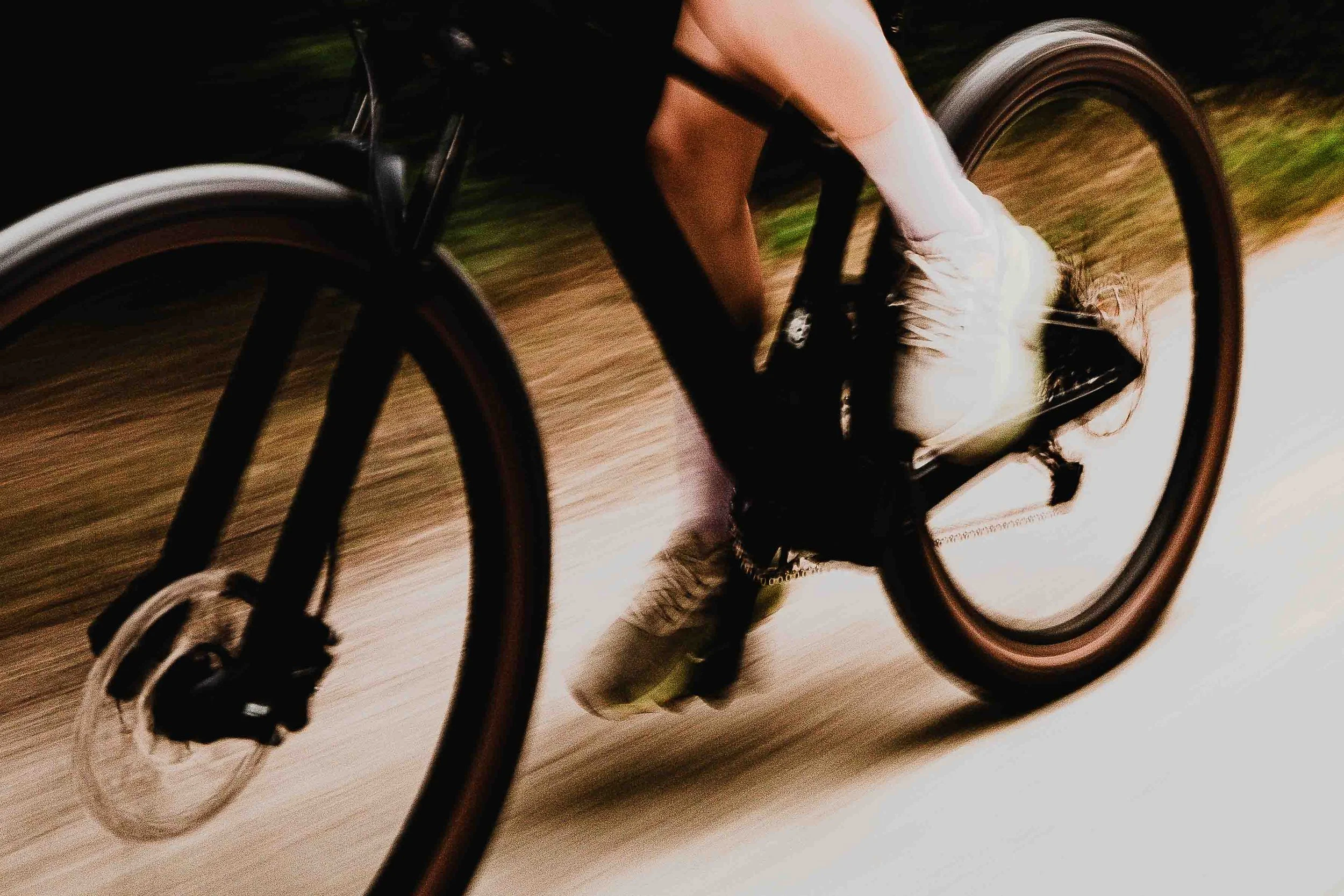 Une personne faisant du vélo sur un chemin en plein air, vue de près en mouvement.