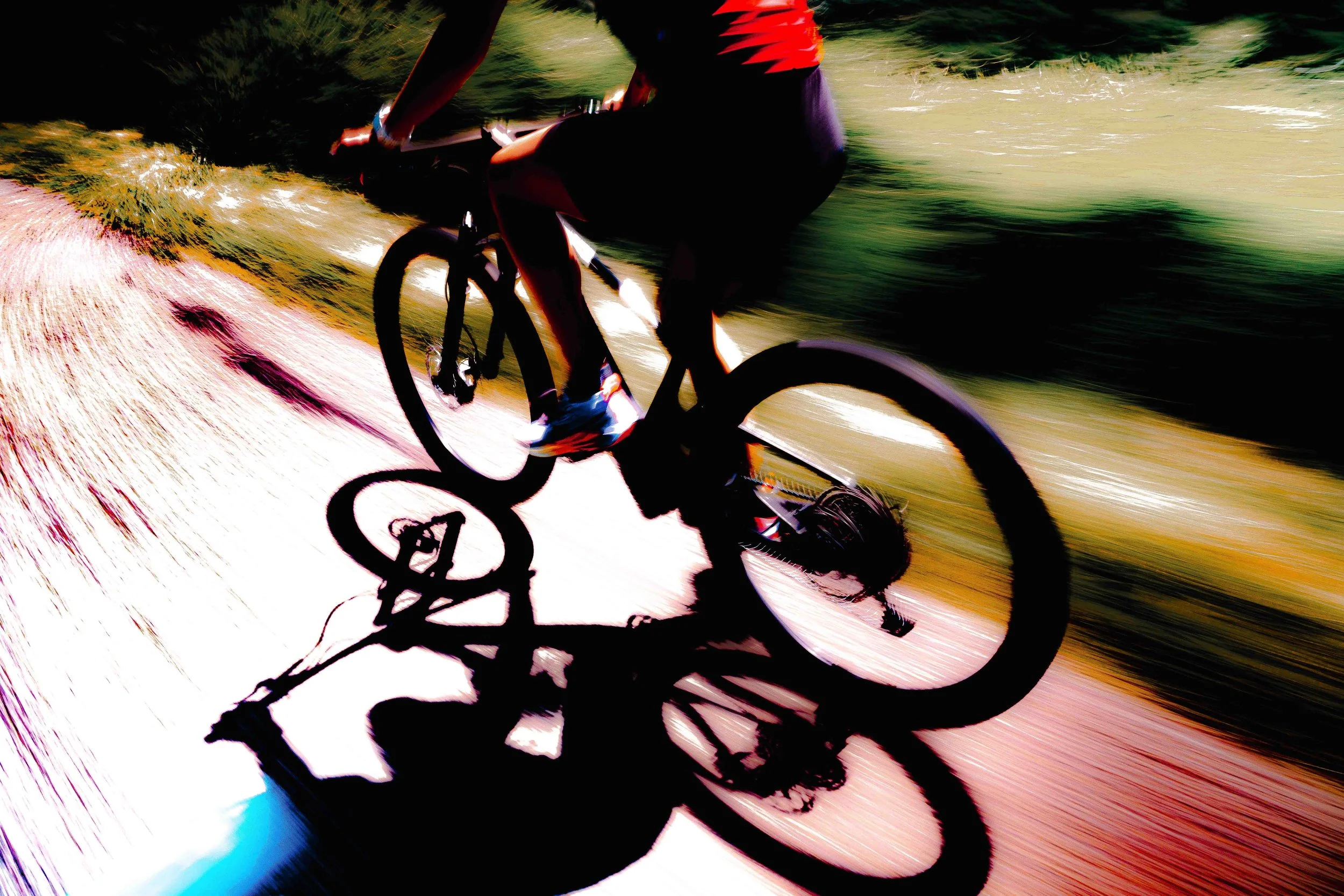 Une personne faisant du vélo sur un sentier en pleine nature, photo prise avec un effet de mouvement flou, créant une impression de vitesse.