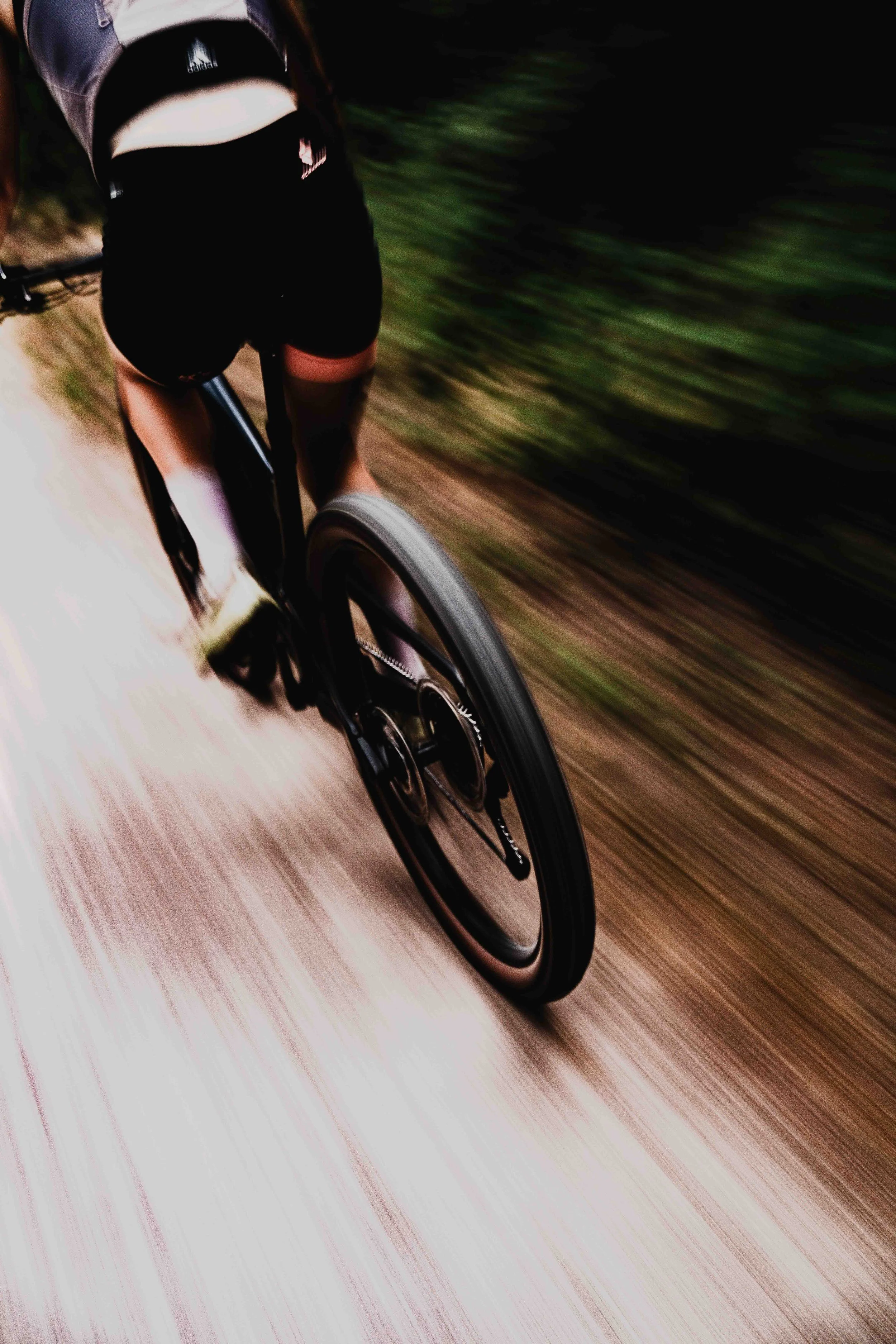Vue d'une personne faisant du vélo sur un chemin de campagne, vue du dessous du vélo avec le mouvement flou en arrière-plan.