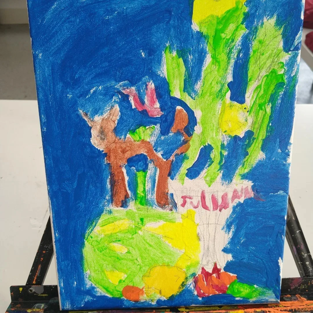 Children's colorful painting of a potted plant with a small animal, possibly a dog, on a paper with the word 'FAMILY' written on it.