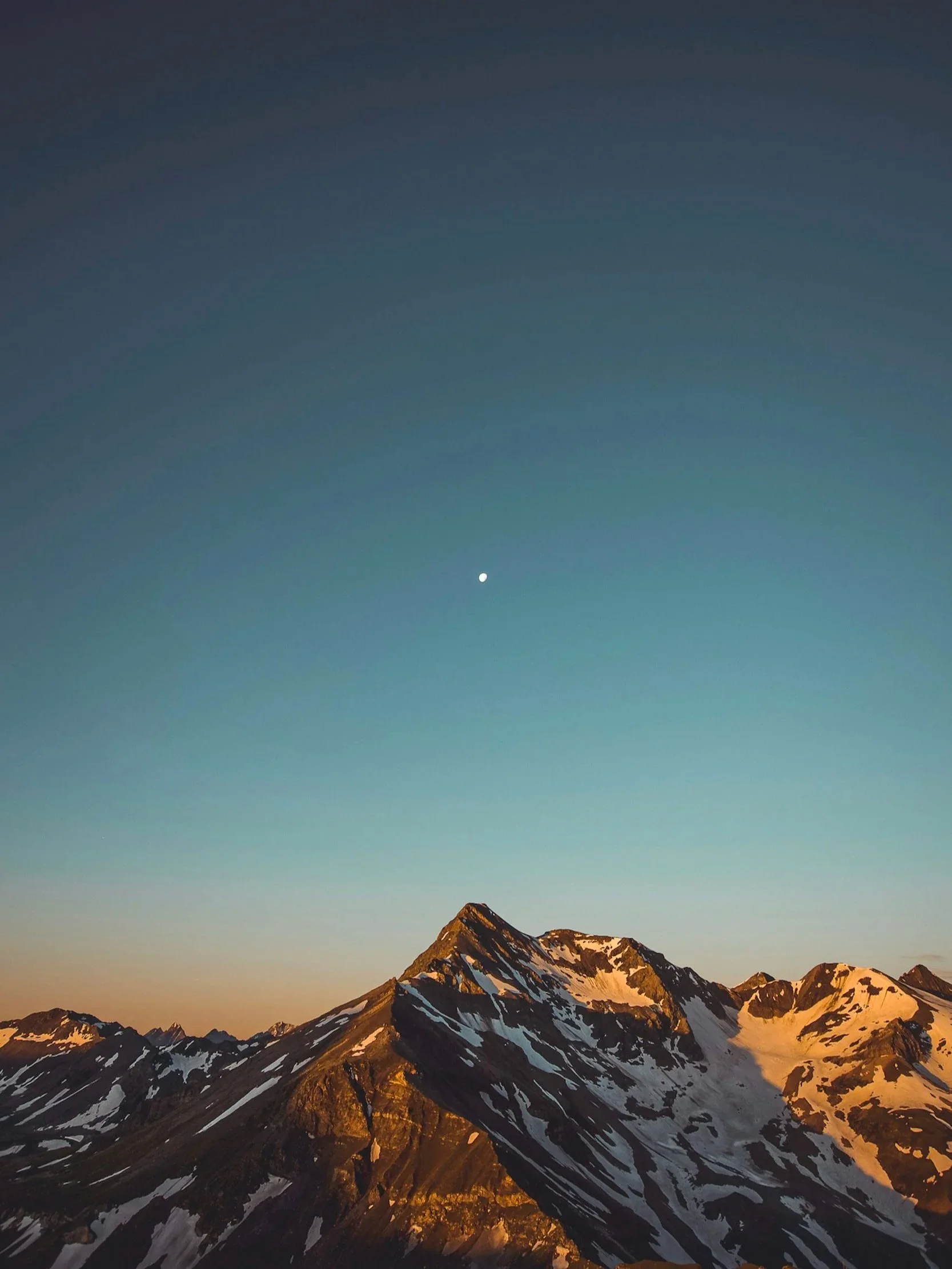 Snow-capped mountain peaks under a twilight sky with visible moon. 9D Breathwork in Greenville SC, Hendersonville NC, Travelers Rest SC, Taylors SC, Greer SC. Somatic Breathwork. Holotropic Breathwork
