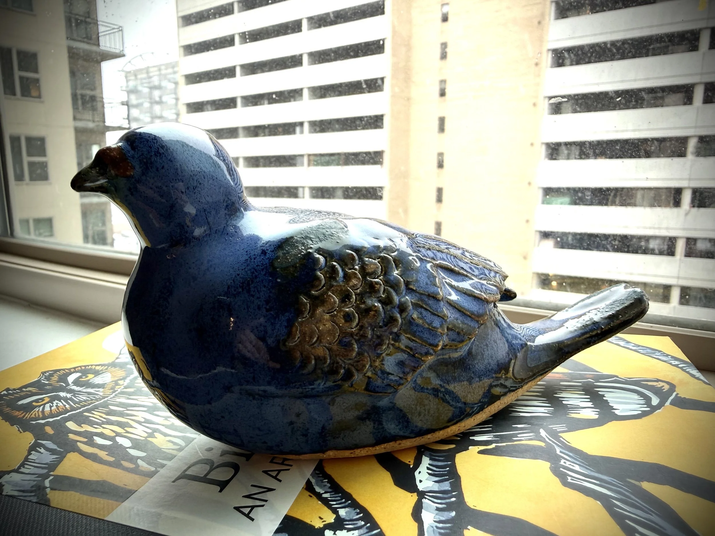 Ceramic pigeon glazed in blue with brown highlights
