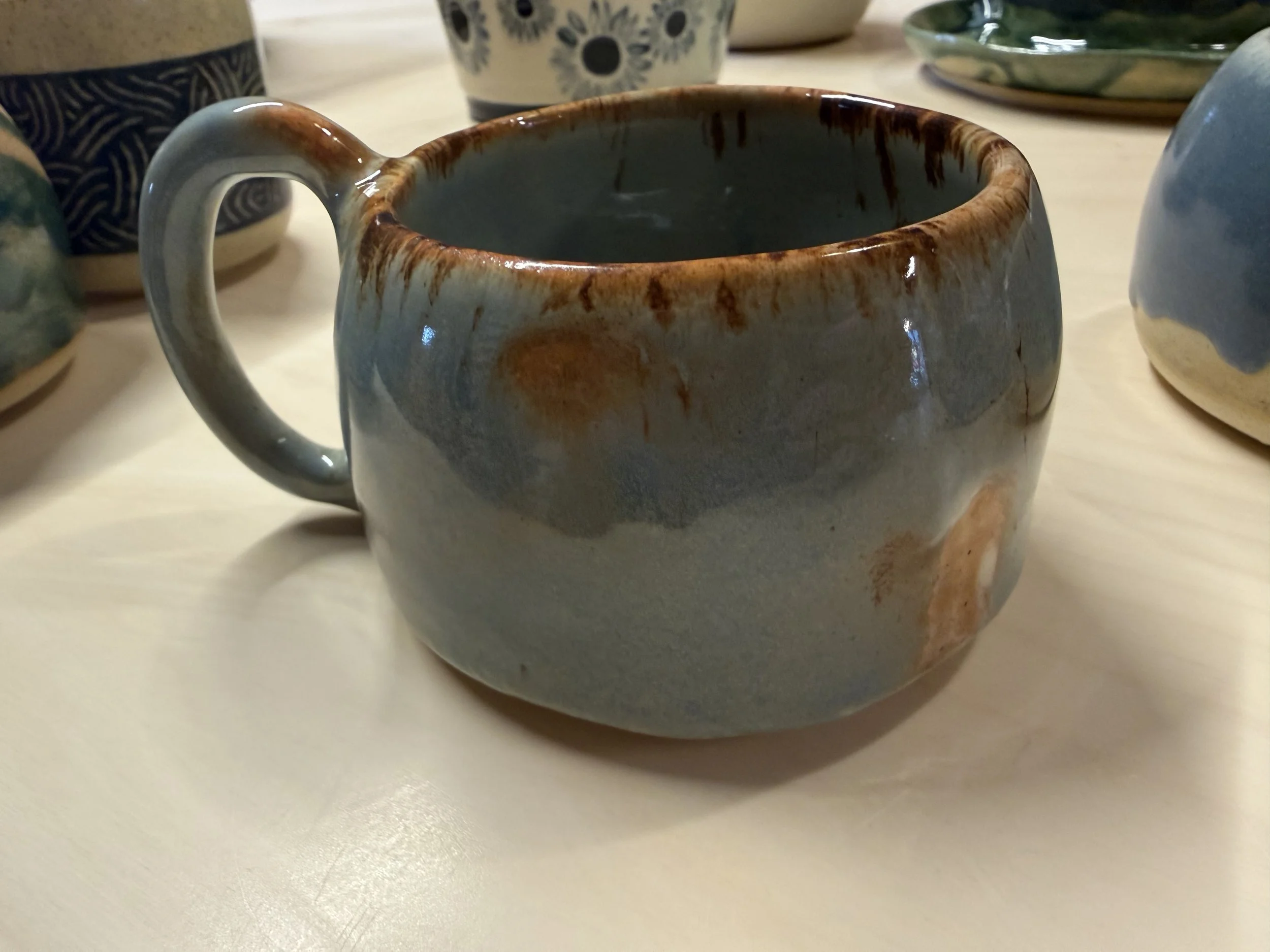 Small blue mug with iron oxide on the rim resembling rust