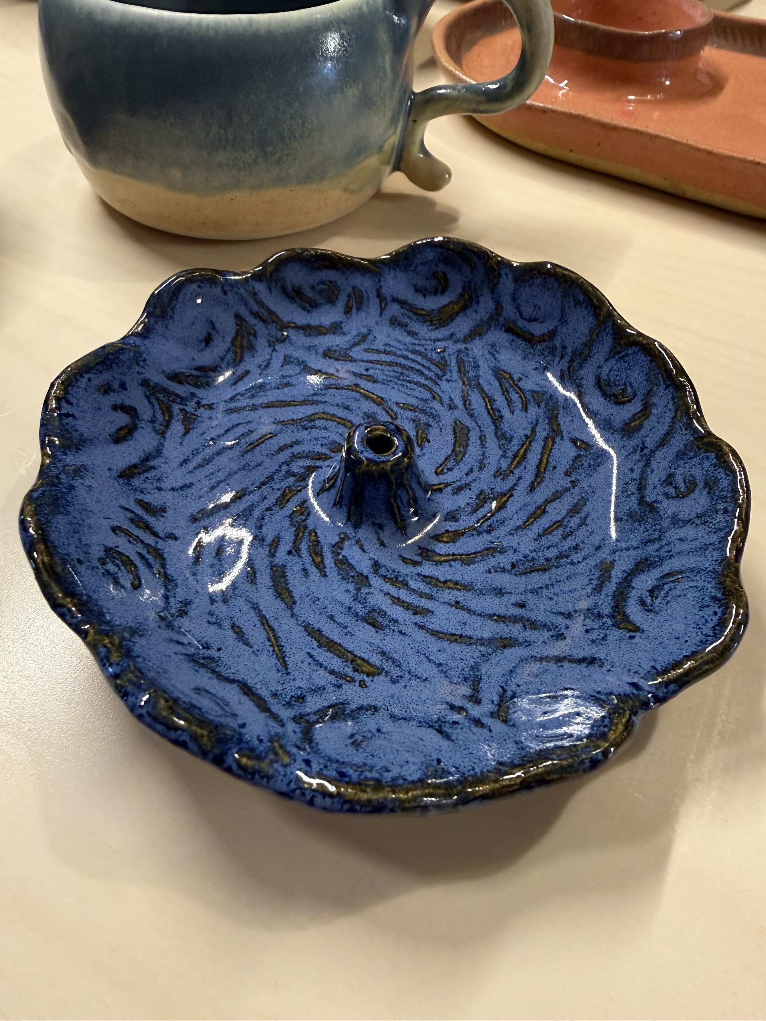Ceramic incense holder carved into wave patterns and glazed deep blue