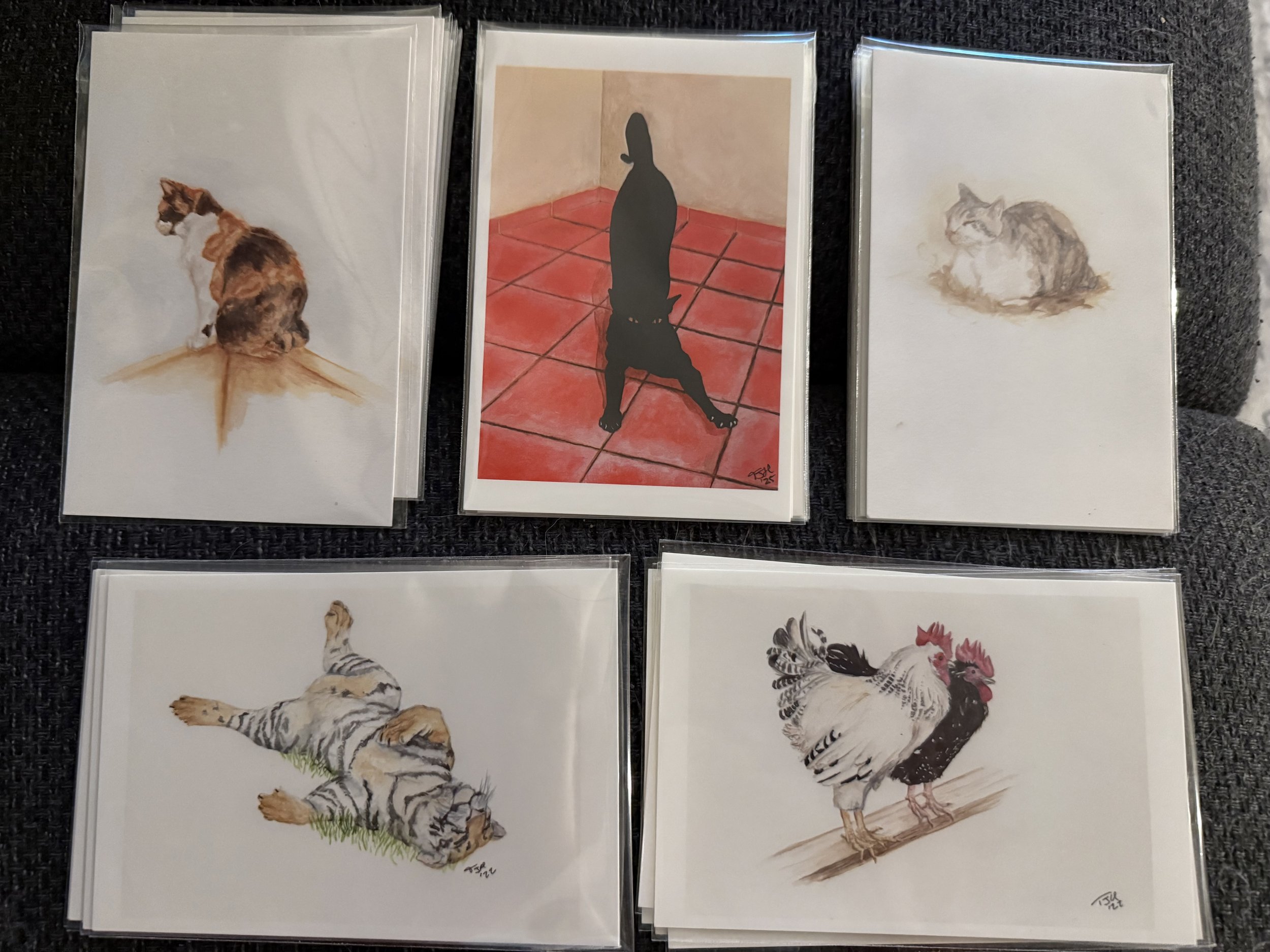 Five art postcards, three with cats in various poses, one with two chickens, and one with a tiger laying on its back.