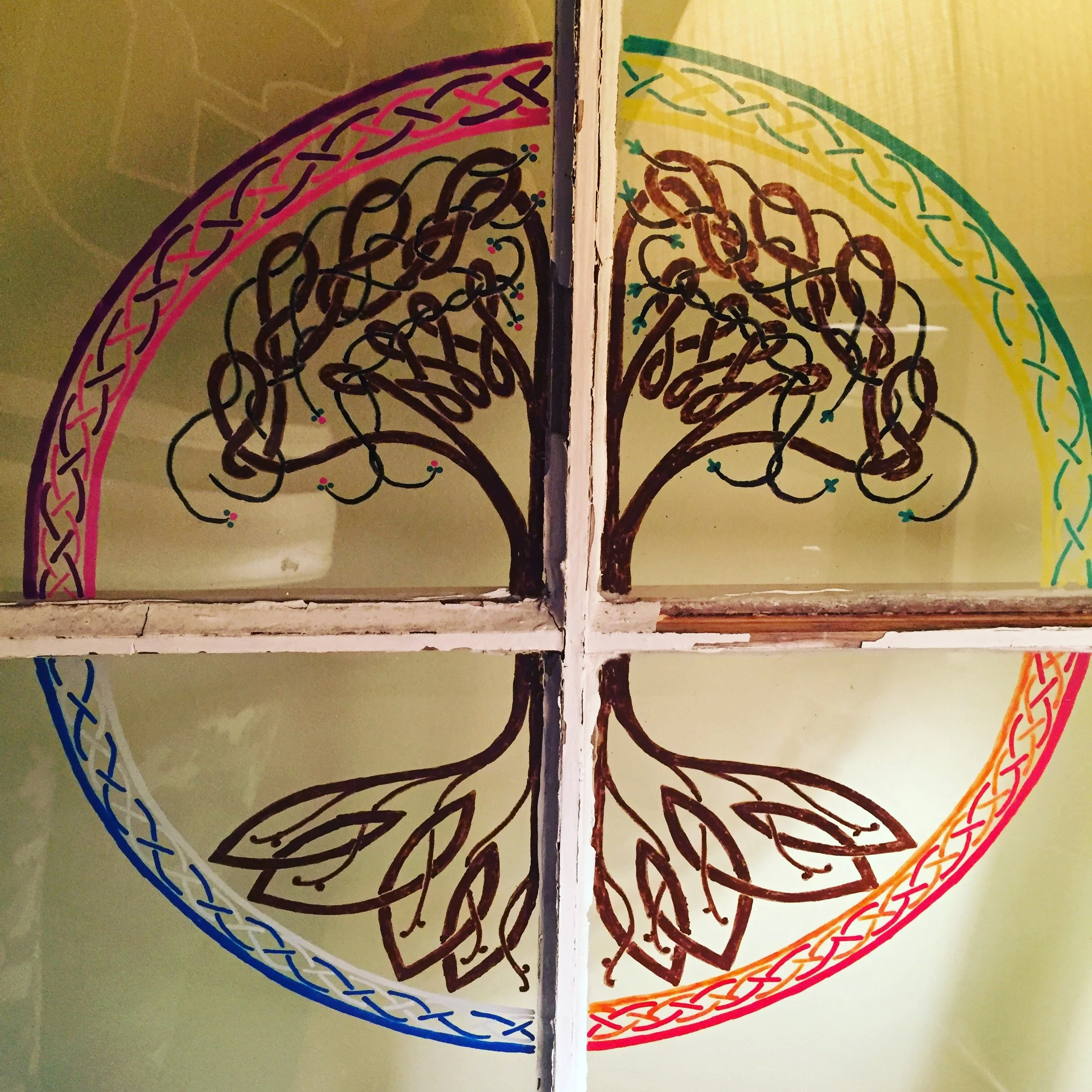 Paint on an antique window in a Celtic style representing the four seasons