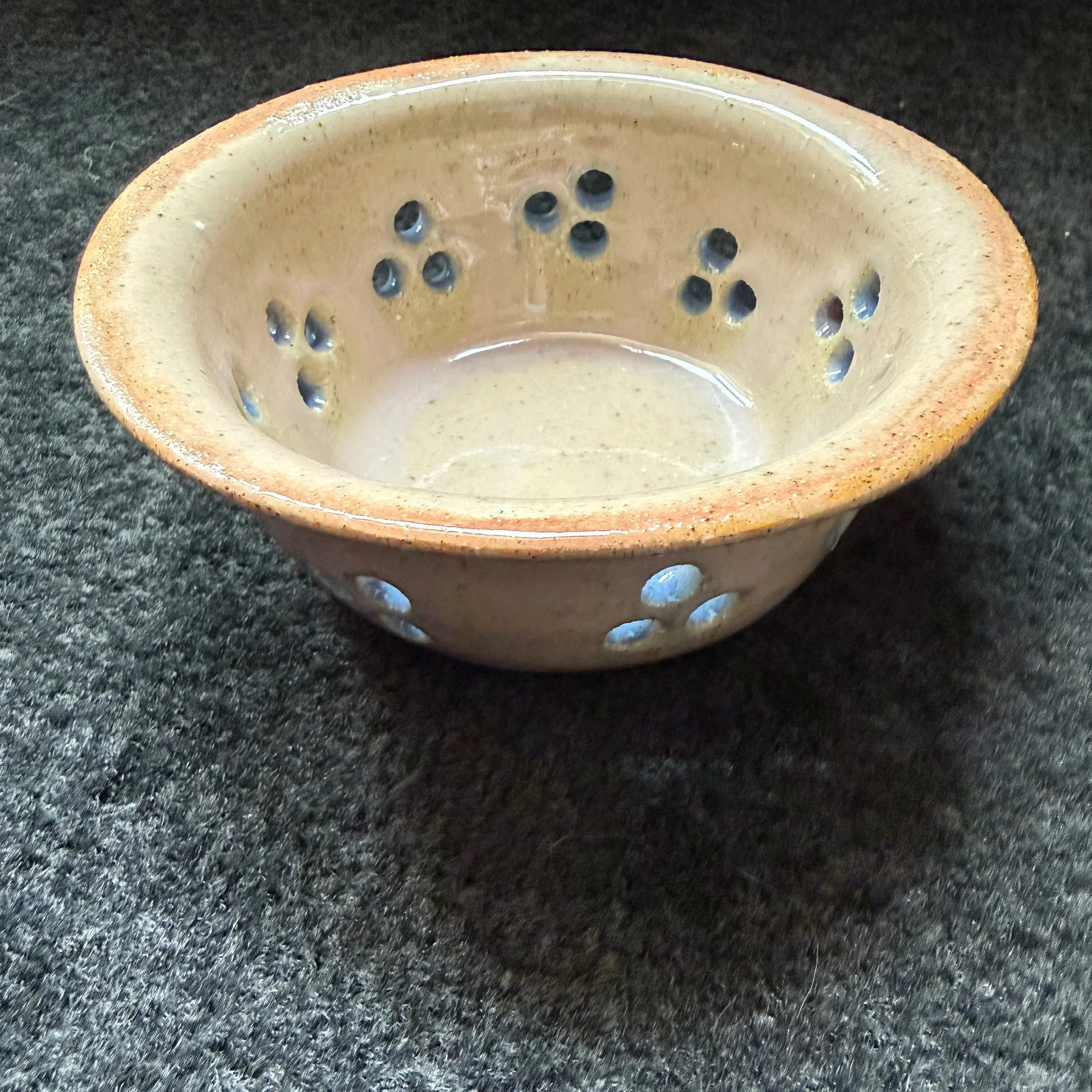 Small ceramic bowl, cream with pink rim and blue holes in the sides, for berries or other uses