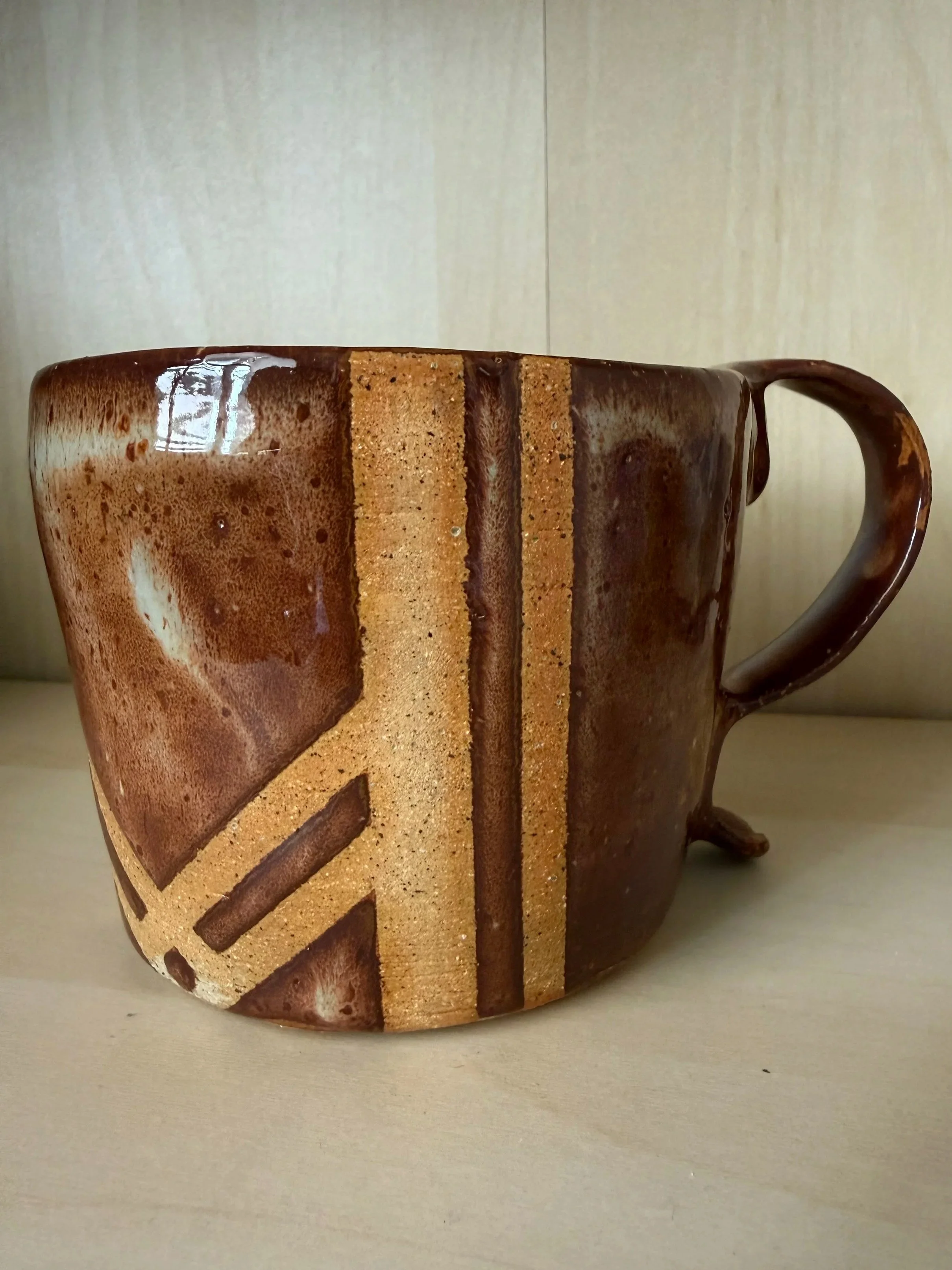 12 ounce coffee mug glazed in brown and mushroom tones with an unglazed pattern