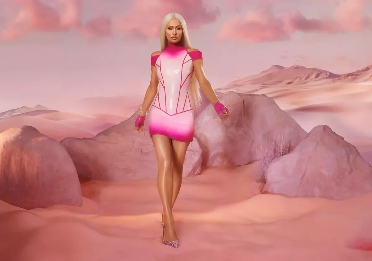 A woman with long blonde hair wearing a pink and white dress with matching gloves, standing in a desert landscape with pink sand and large rocks, under pinkish clouds.