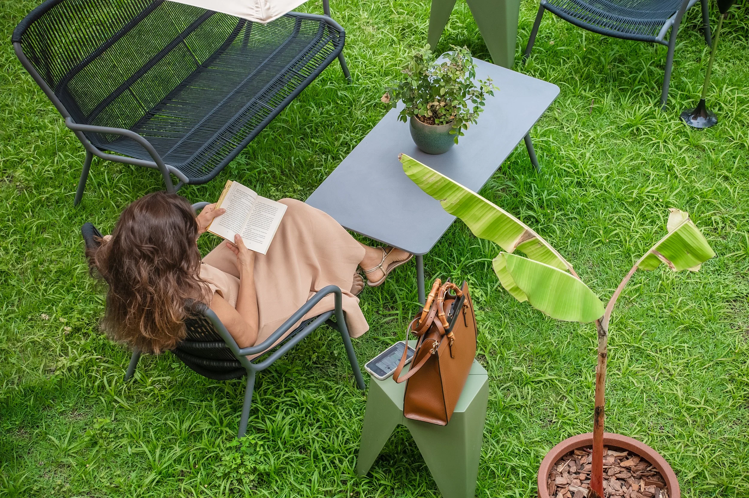 Pessoa lendo na Varanda Leda da Casa Cuia em Perdizes, ambiente externo para trabalho, leitura e contemplação.