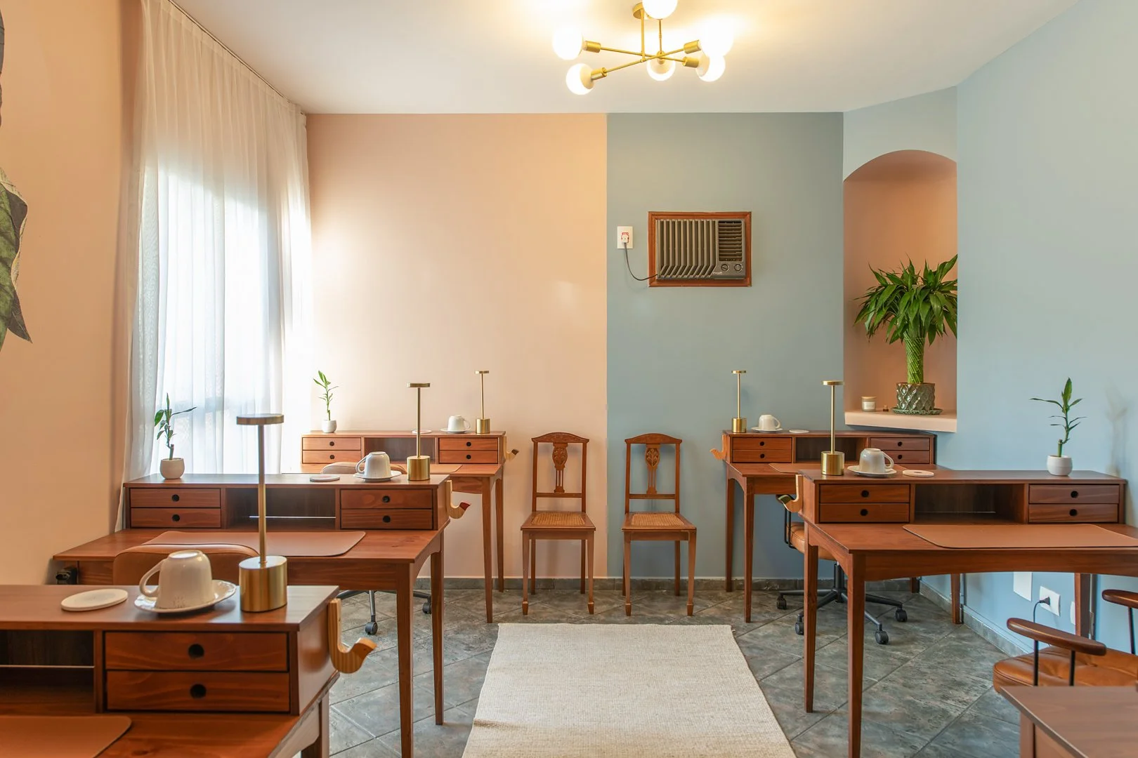 Mesas e assentos da Sala Clarice da Casa Cuia, espaço de coworking com mesas rotativas para pesquisa e trabalho.