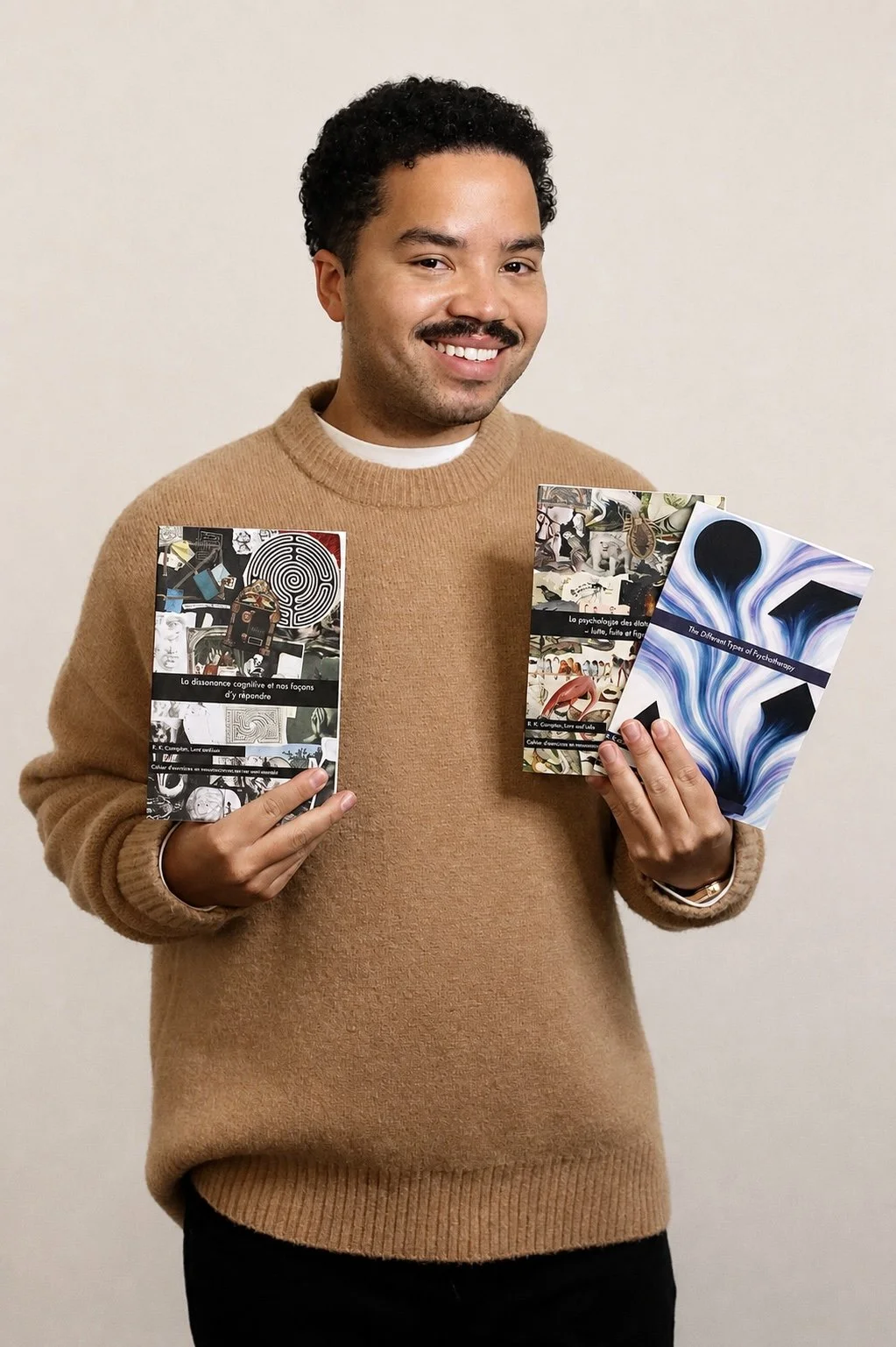 A man smiling and holding three books about psychology and neuroscience.