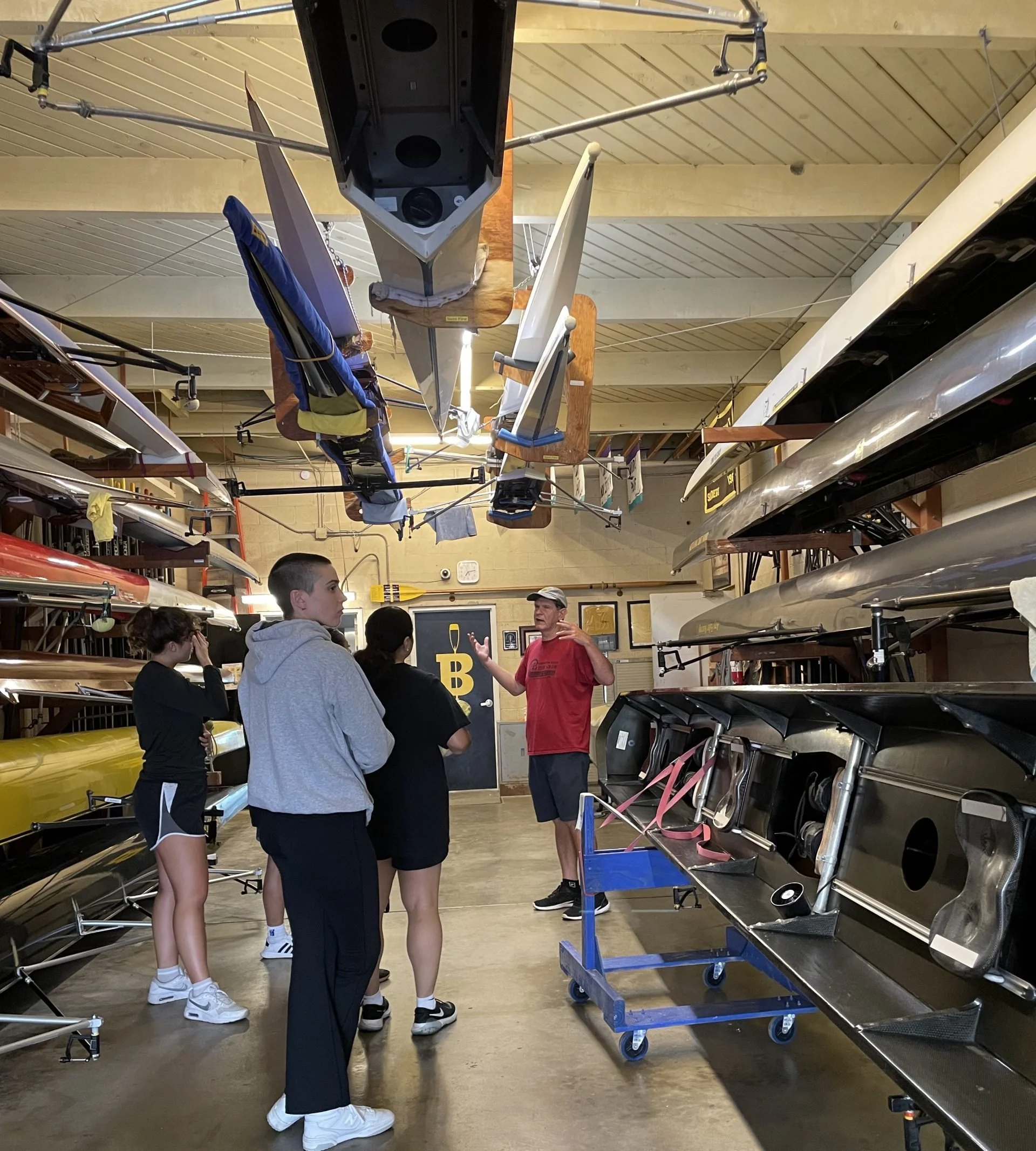 Coach Mike McAndrews gives the women's crew a tour of their boats.
