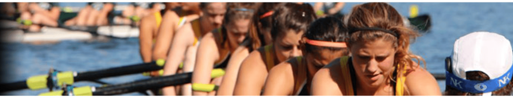 A team of female rowers in a boat, competing in a rowing race on a body of water.