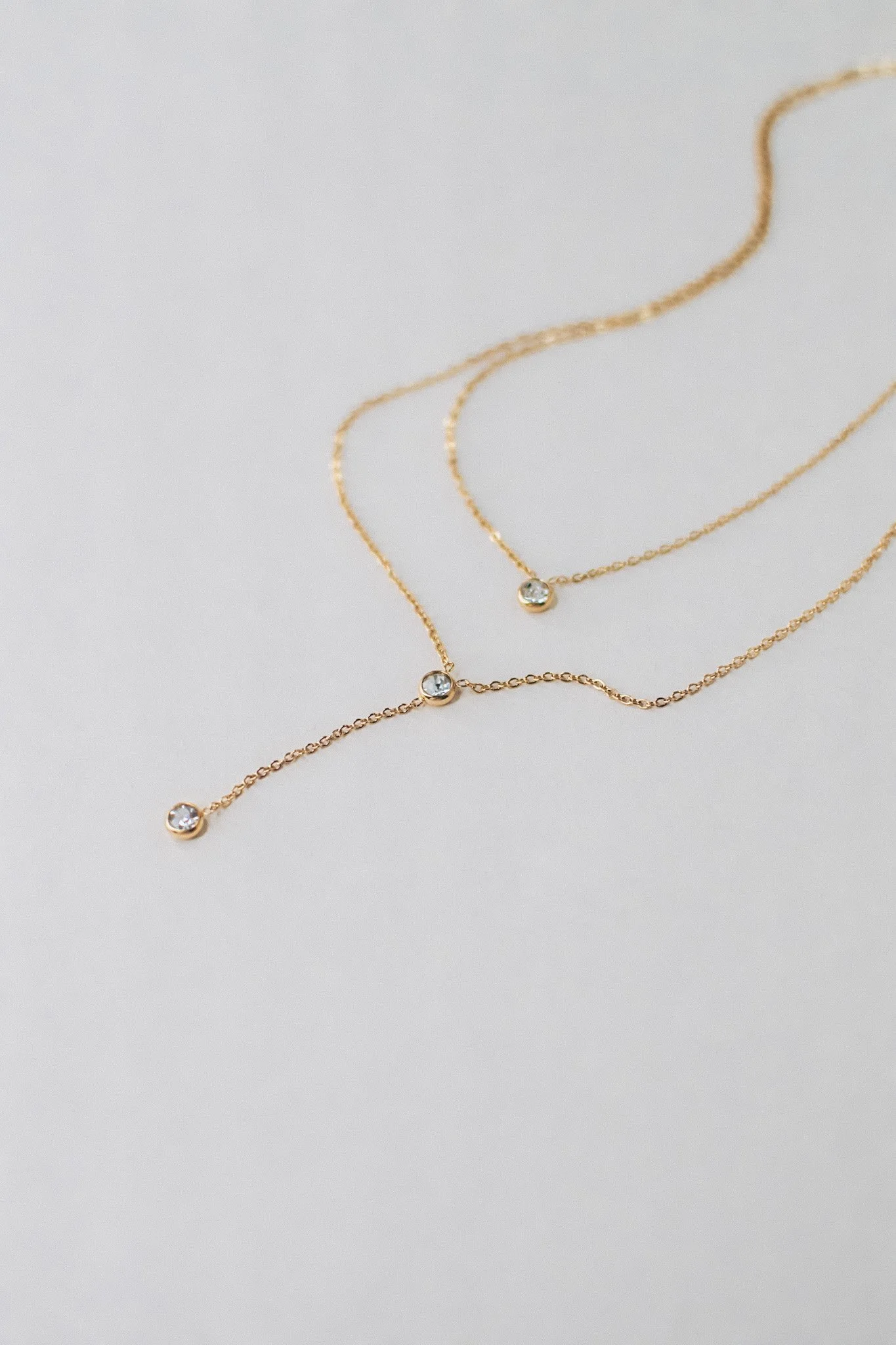 Bianca dainty gold double necklace with bezel-set cubic zirconia stones, available at Vienna Studio jewelry in Calgary.