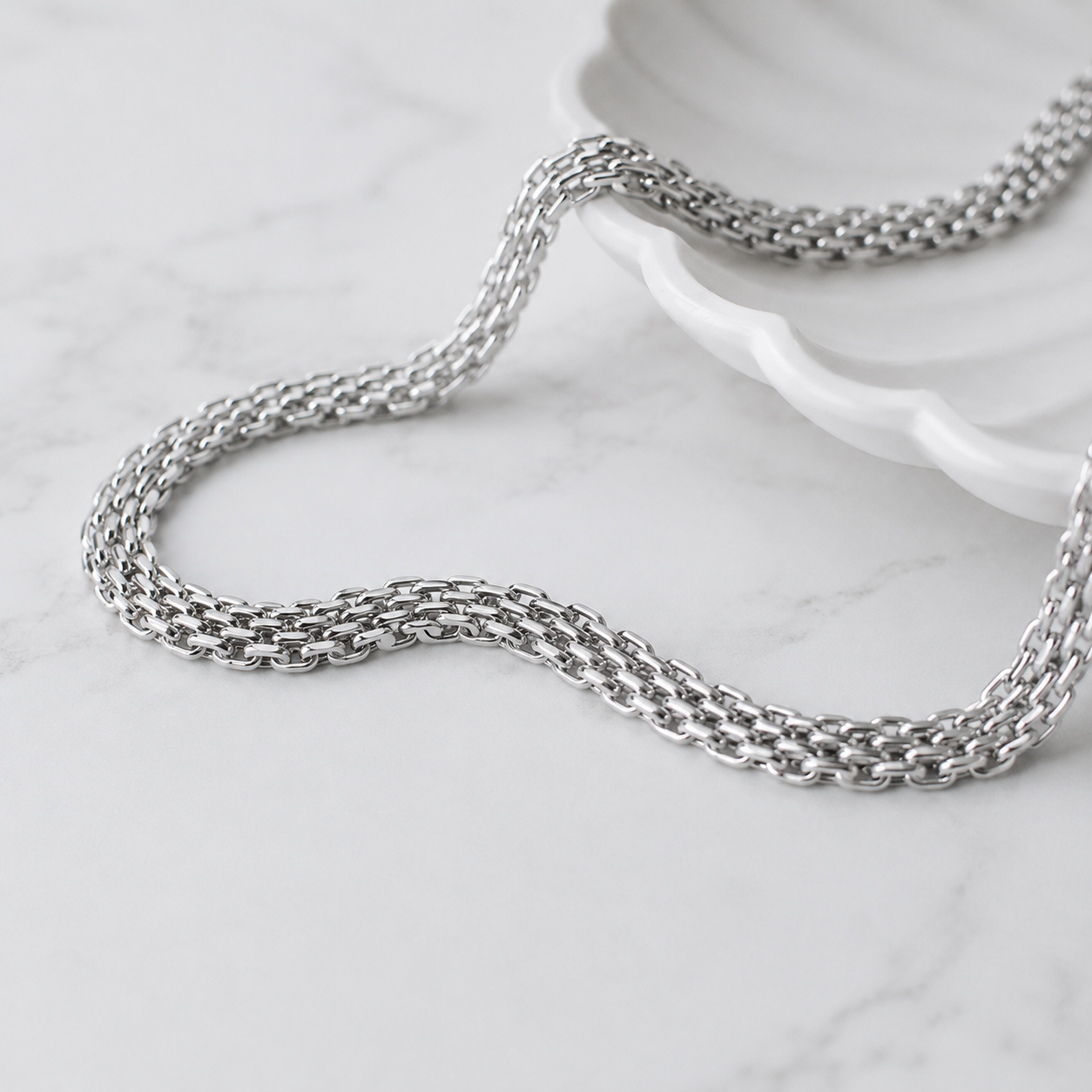 House of Avorio Luna Italian Link Strap Necklace in polished silver stainless steel featuring a multi-strand Italian chain design on a white marble background.