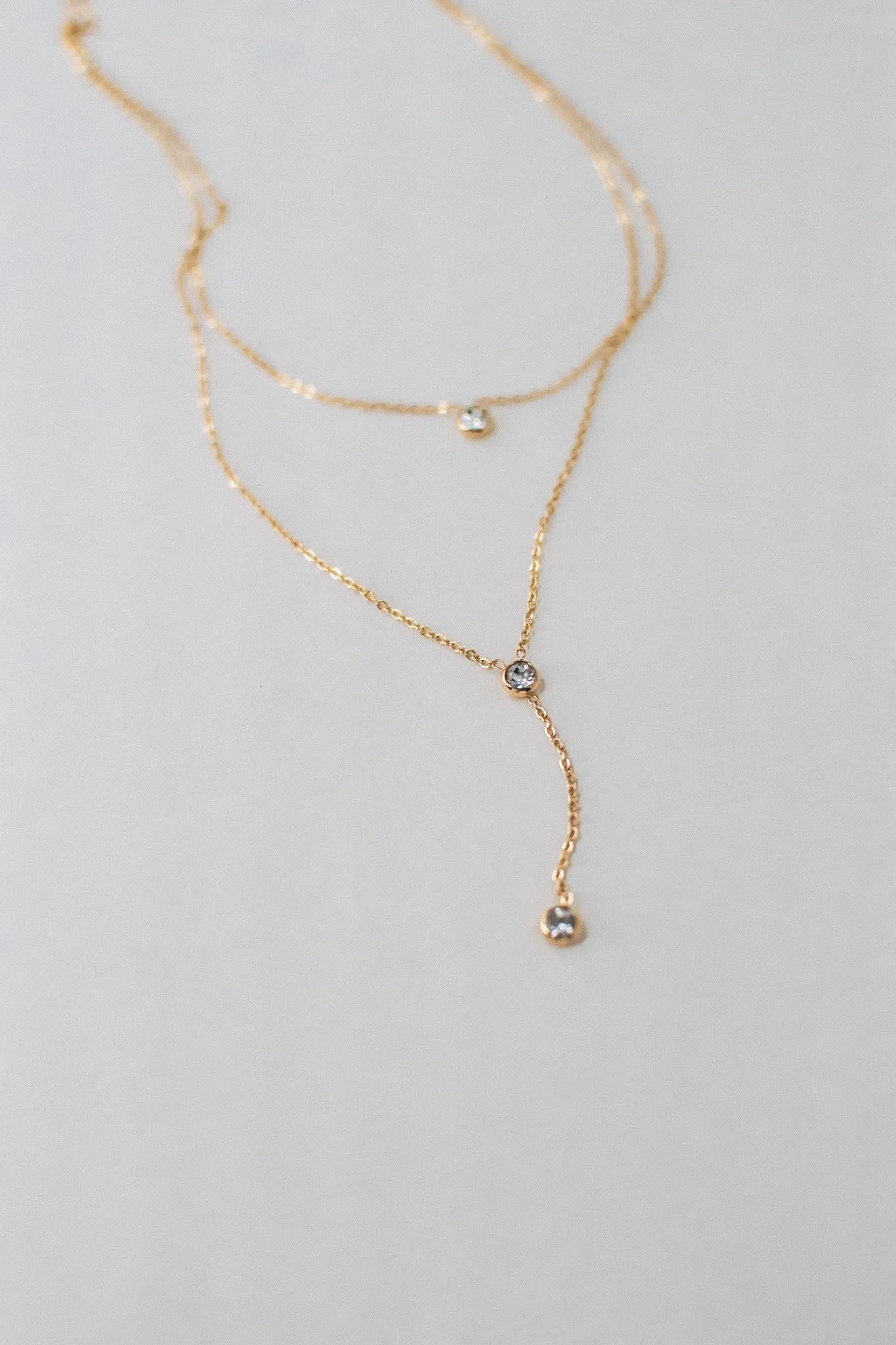 Bianca dainty gold double necklace with bezel-set cubic zirconia stones, available at Vienna Studio jewelry in Calgary.